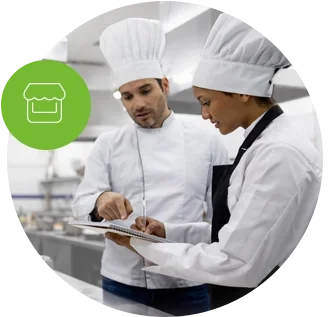 Chef talking to a student in a cooking class. Find Restaurant and Food Business Insurance Coverage.