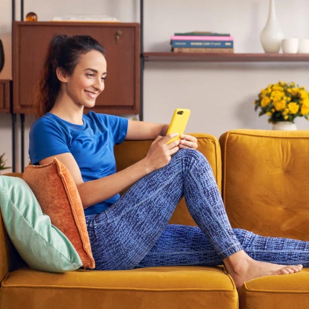 A woman on a bench with a phone.