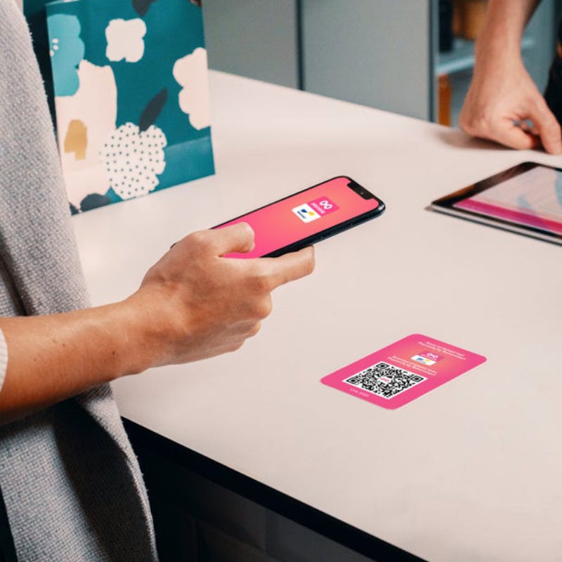 Een persoon die een telefoon vasthoudt en een qr-code scant