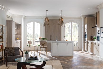 An open concept kitchen with white cabinets and wood floors.