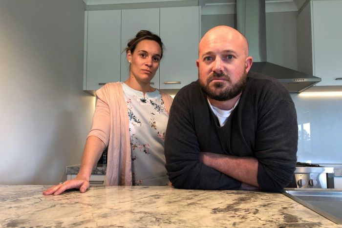Man and woman leaning on stone benchtop