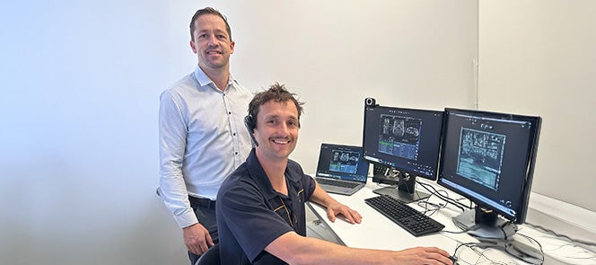 Two I-MED Radiology technicians in front of screens reading the images from remote location MRI