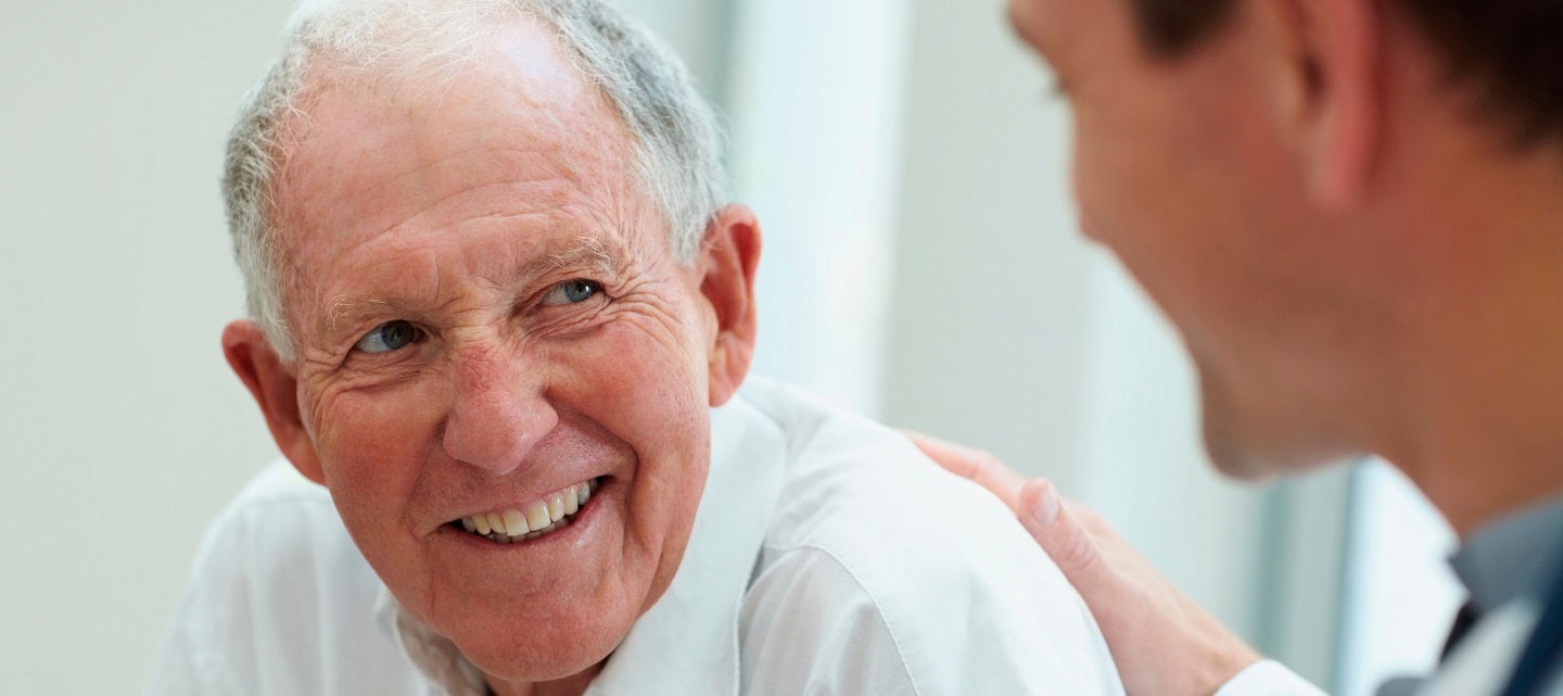 Older man being reassured by younger doctor
