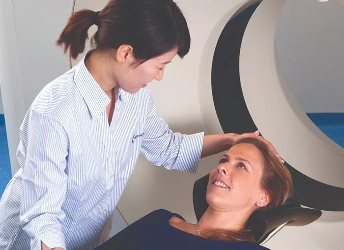 Caring staff member with patient having CT scan