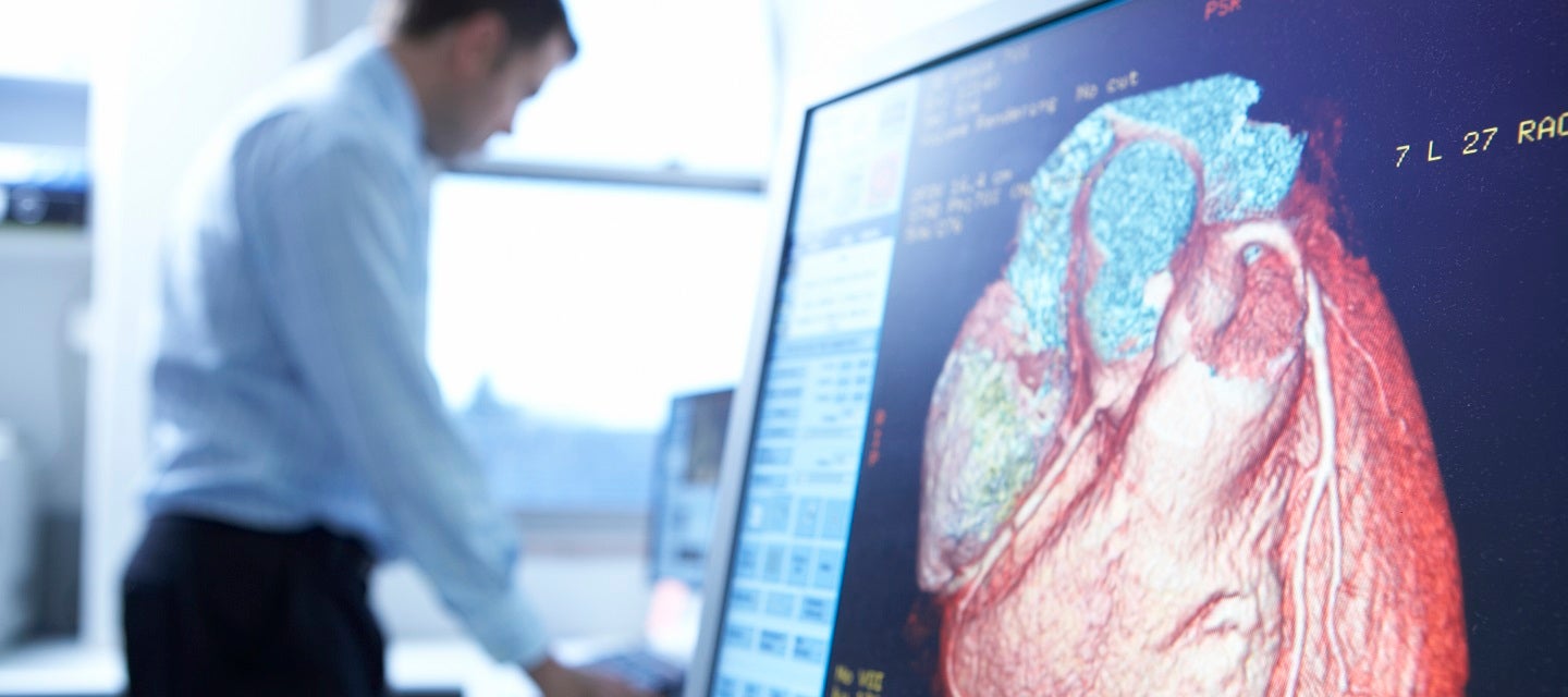 Radiologist with CT of heart on screen