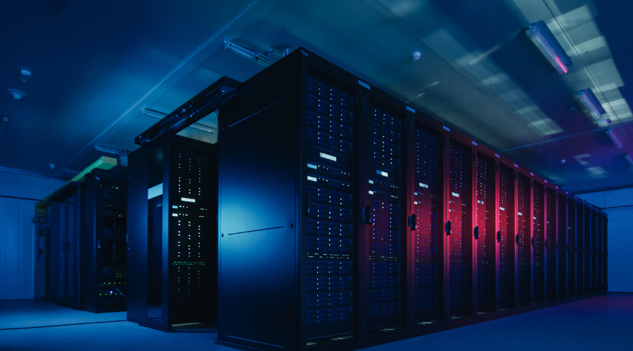 Data center with rows of black server cabinets illuminated by blue and red lighting