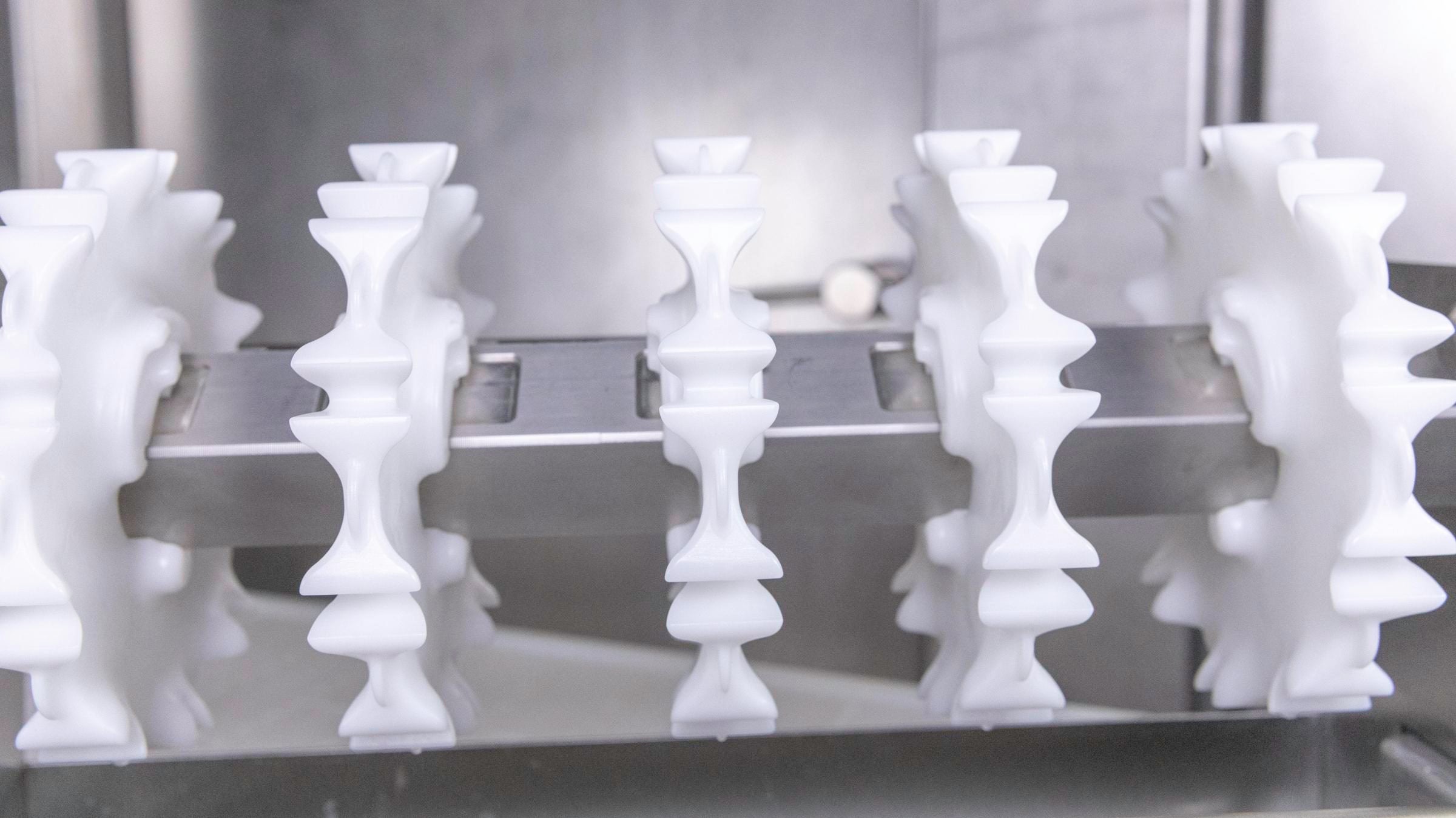 White Intralox CleanLock sprockets secured to conveyor shaft