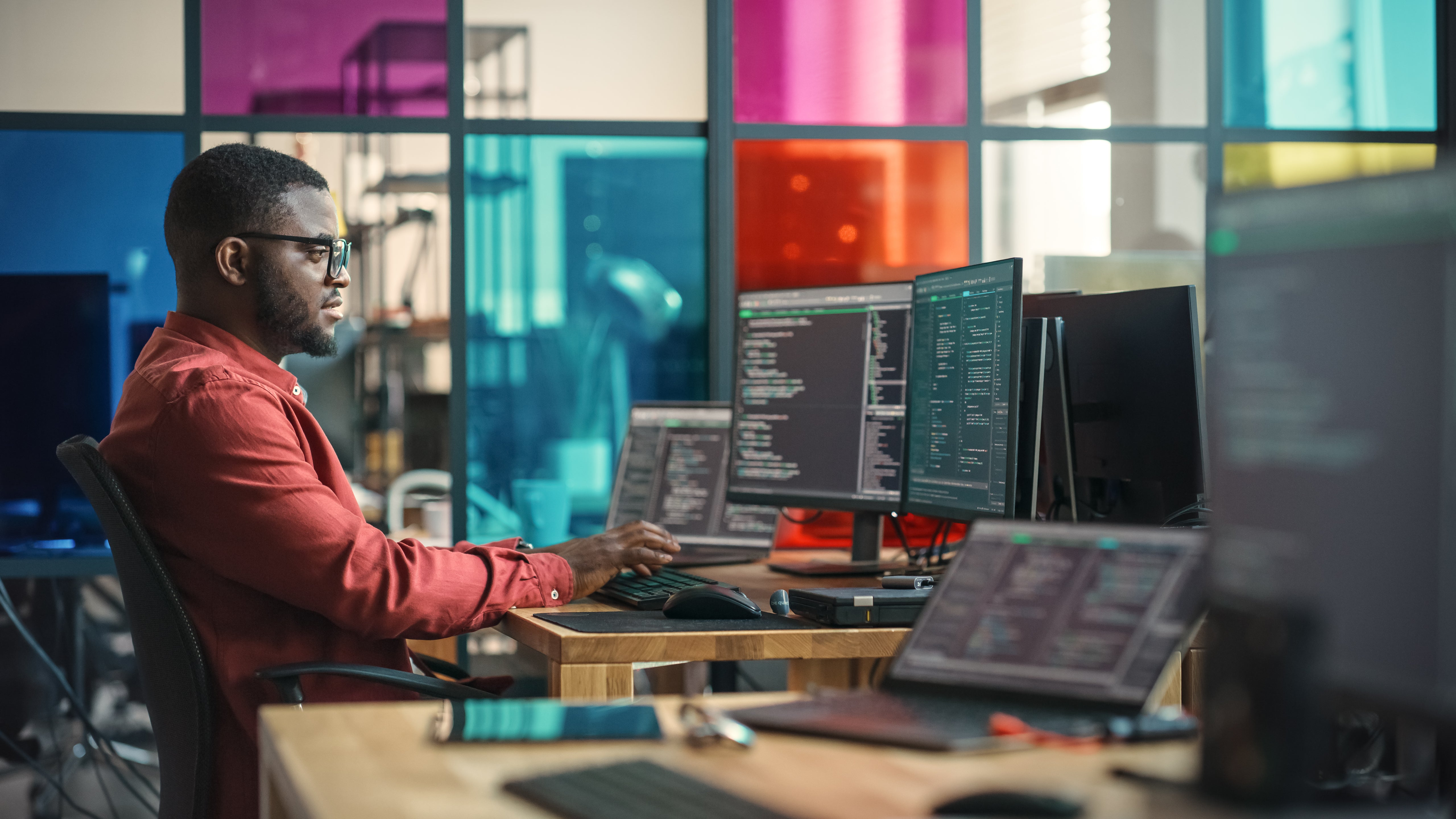 Man sitting at a desk working on a computer generating code