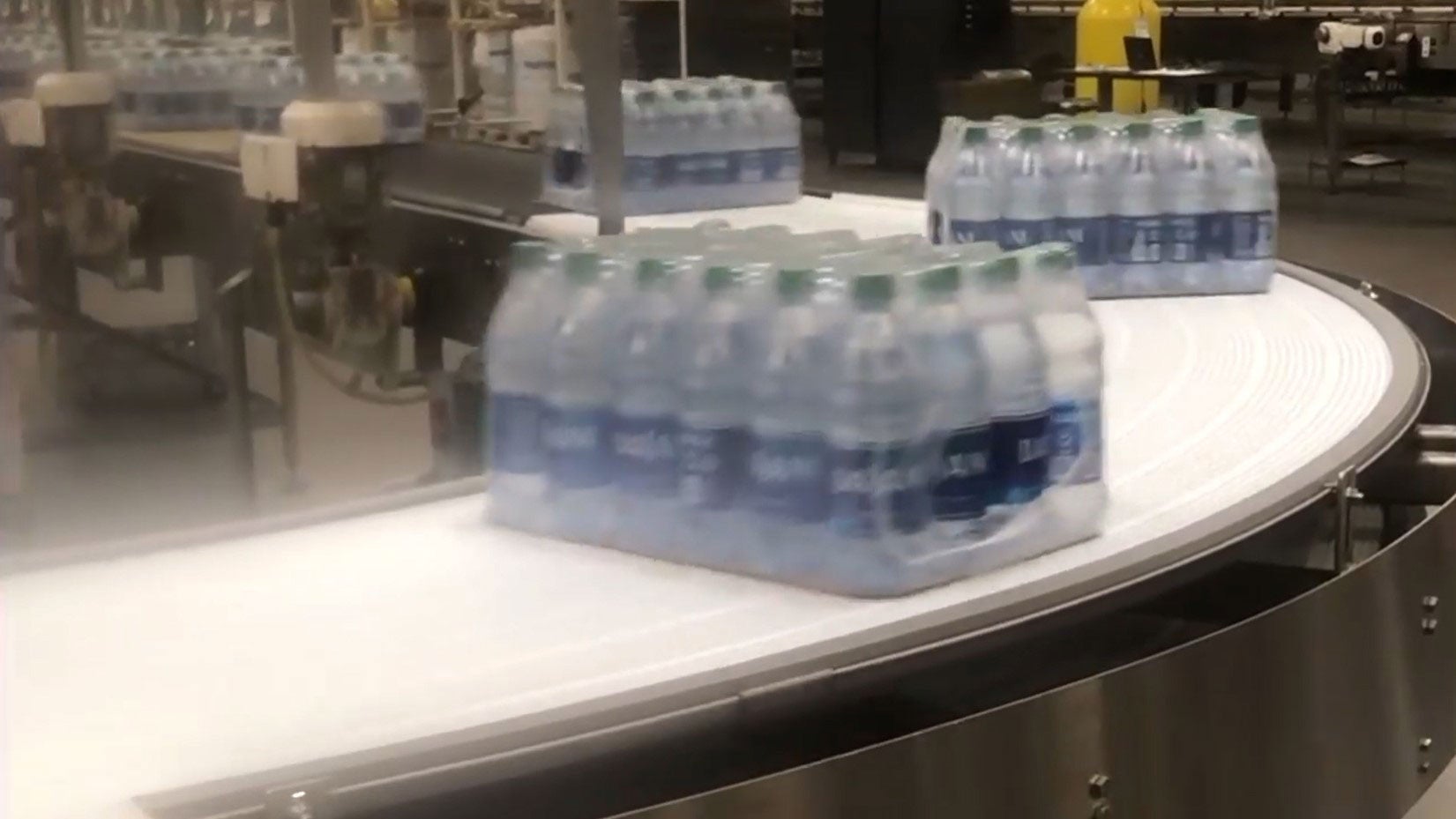 Cases of water bottles on curved conveyor belt