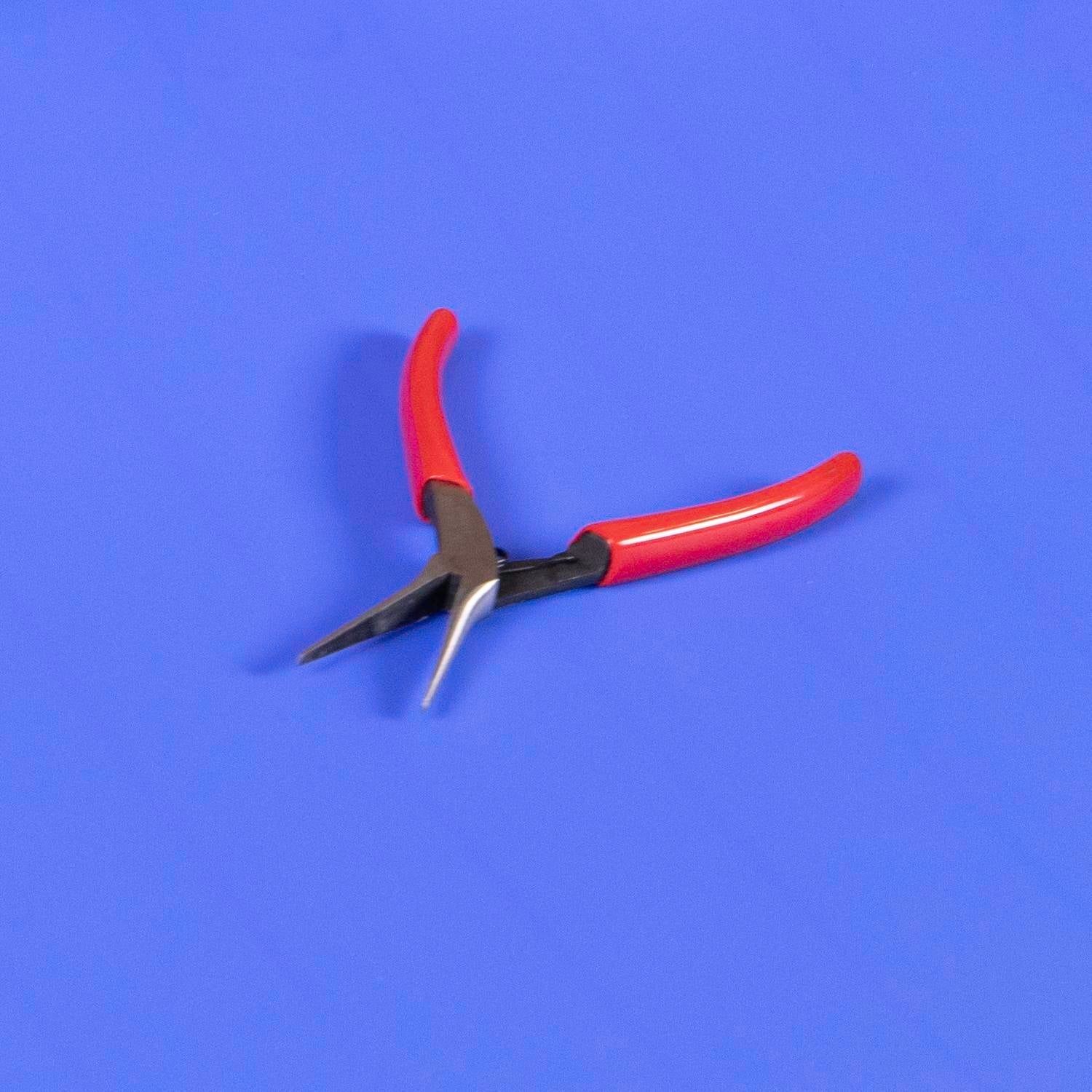 Ein Paar Mini-Spitzzangen mit rotem Griff, die auf einem blauen ThermoDrive-Band offen liegen
