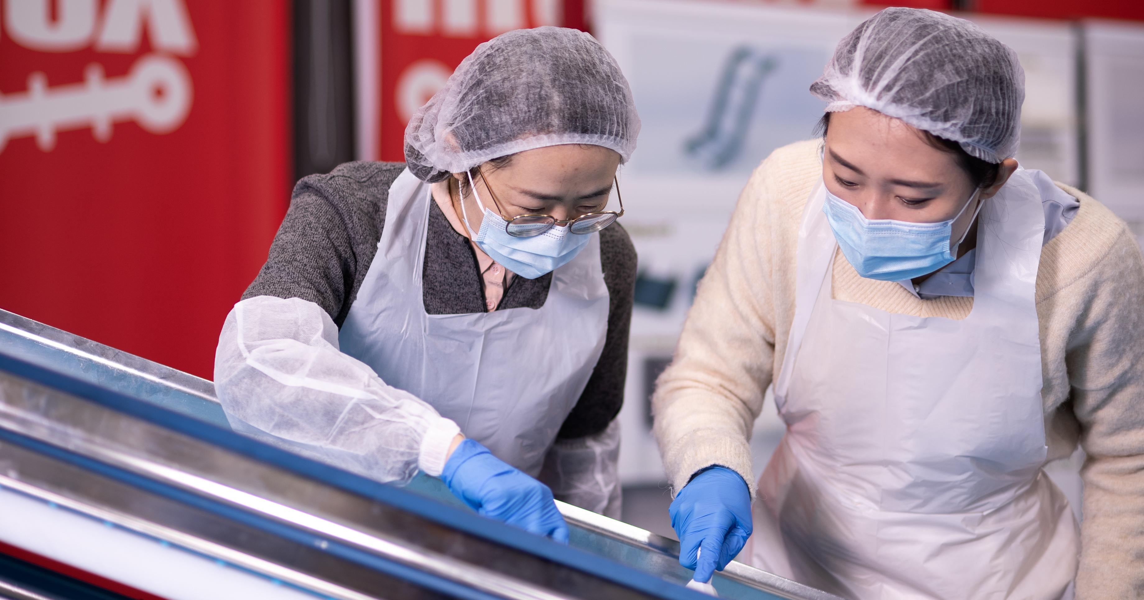 Zwei Frauen mit Handschuhen, Haarnetzen und Kitteln reinigen das ThermoDrive-Band