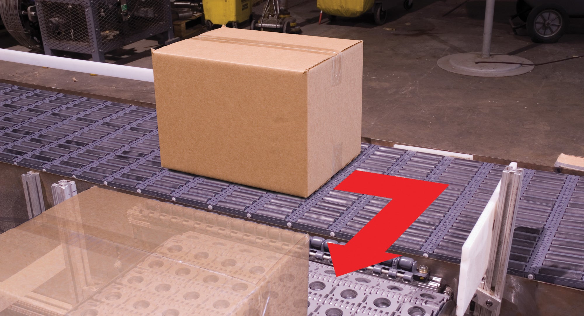 Pudełka zjeżdżające z przenośnika ARB zgodnie z kierunkiem wskazanym strzałką