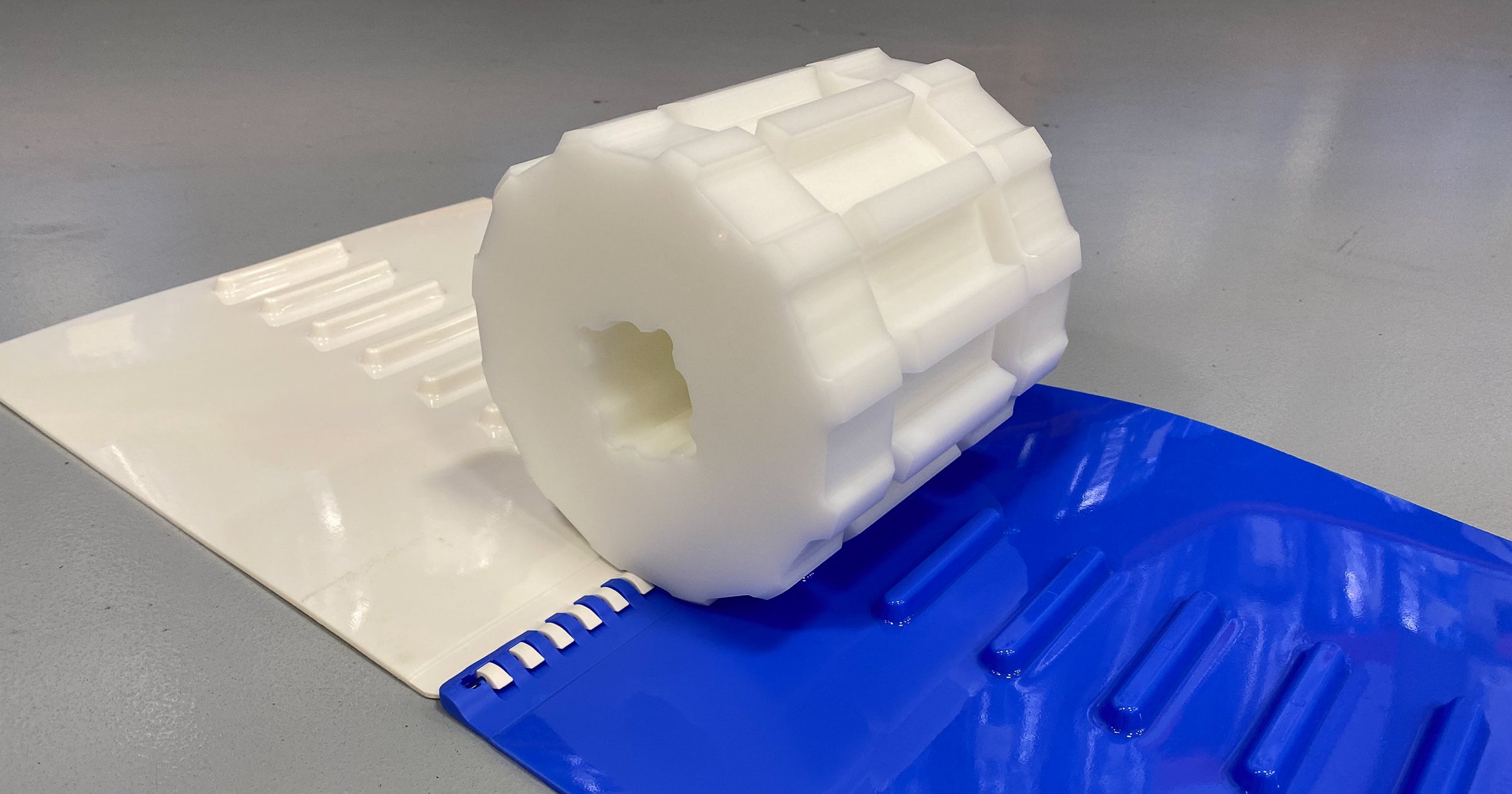 ThermoLace-Rillenritzel oben auf den blauen und weißen ThermoDrive 8140-Bandabschnitten mit Einzelstollen