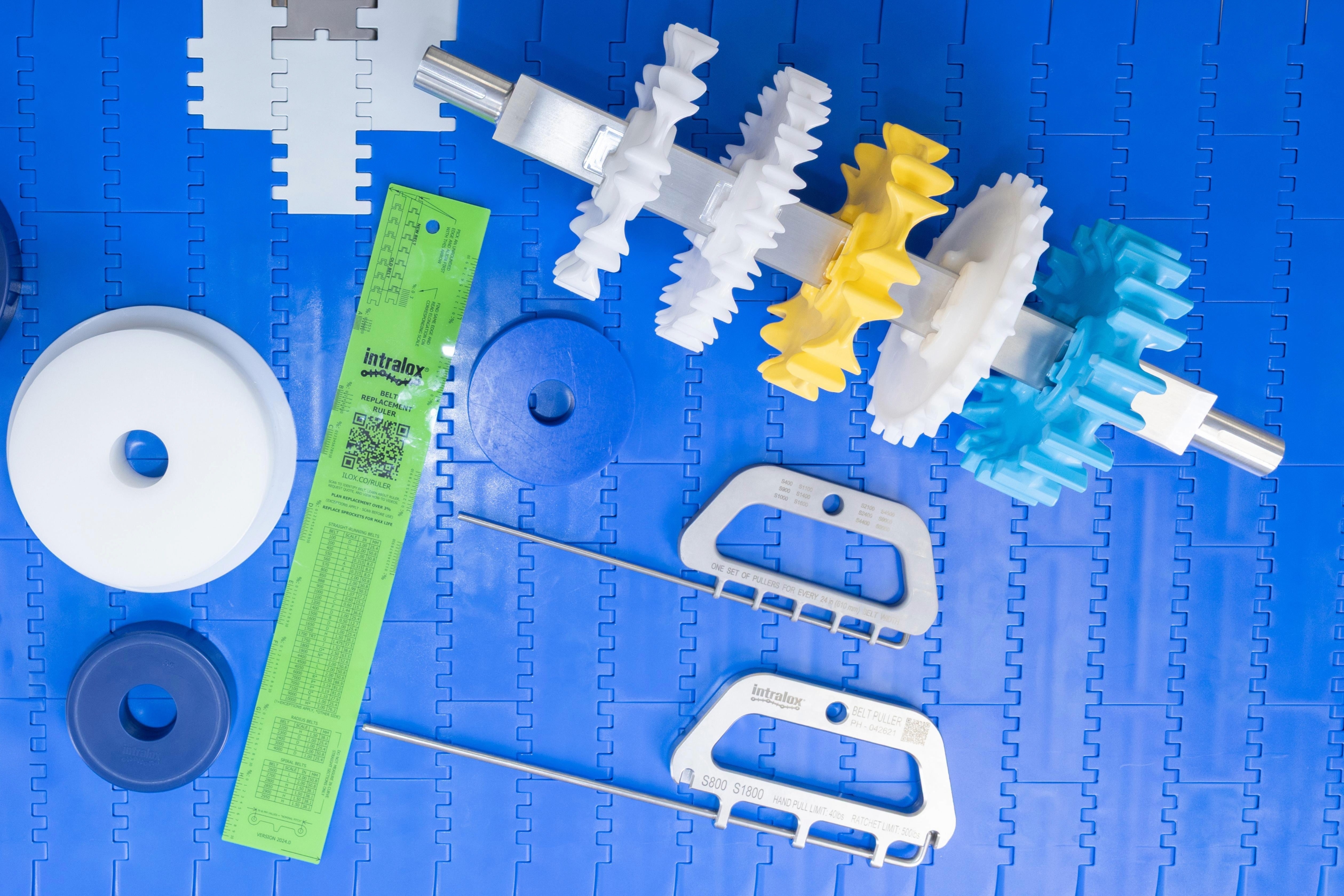 Various OneTrack tools and components arrayed on blue conveyor belt