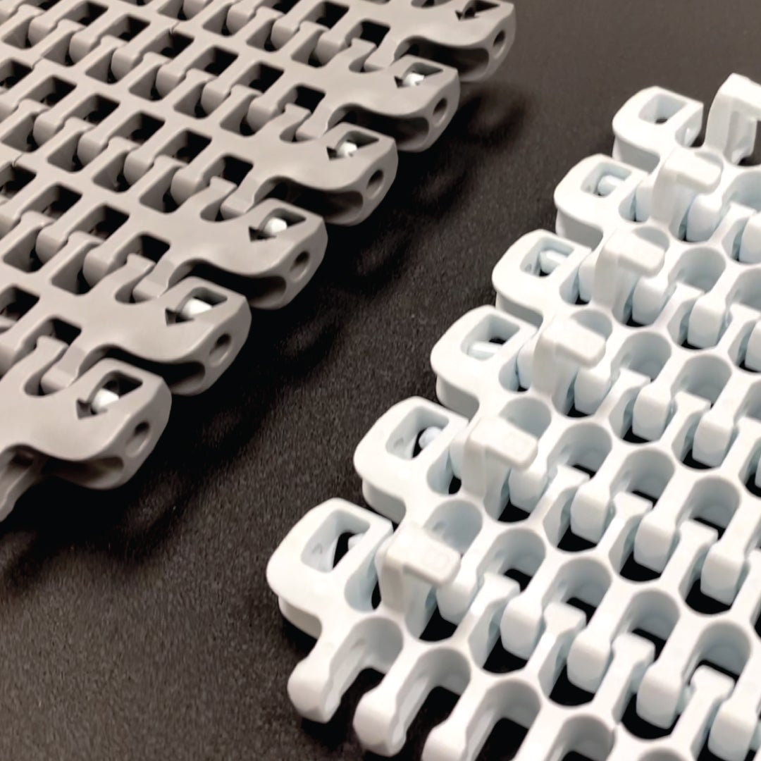 HDE-Radius-Förderbänder der Serie 2400, mit Pfeilen an der Bandkante und Niederhalteführungen