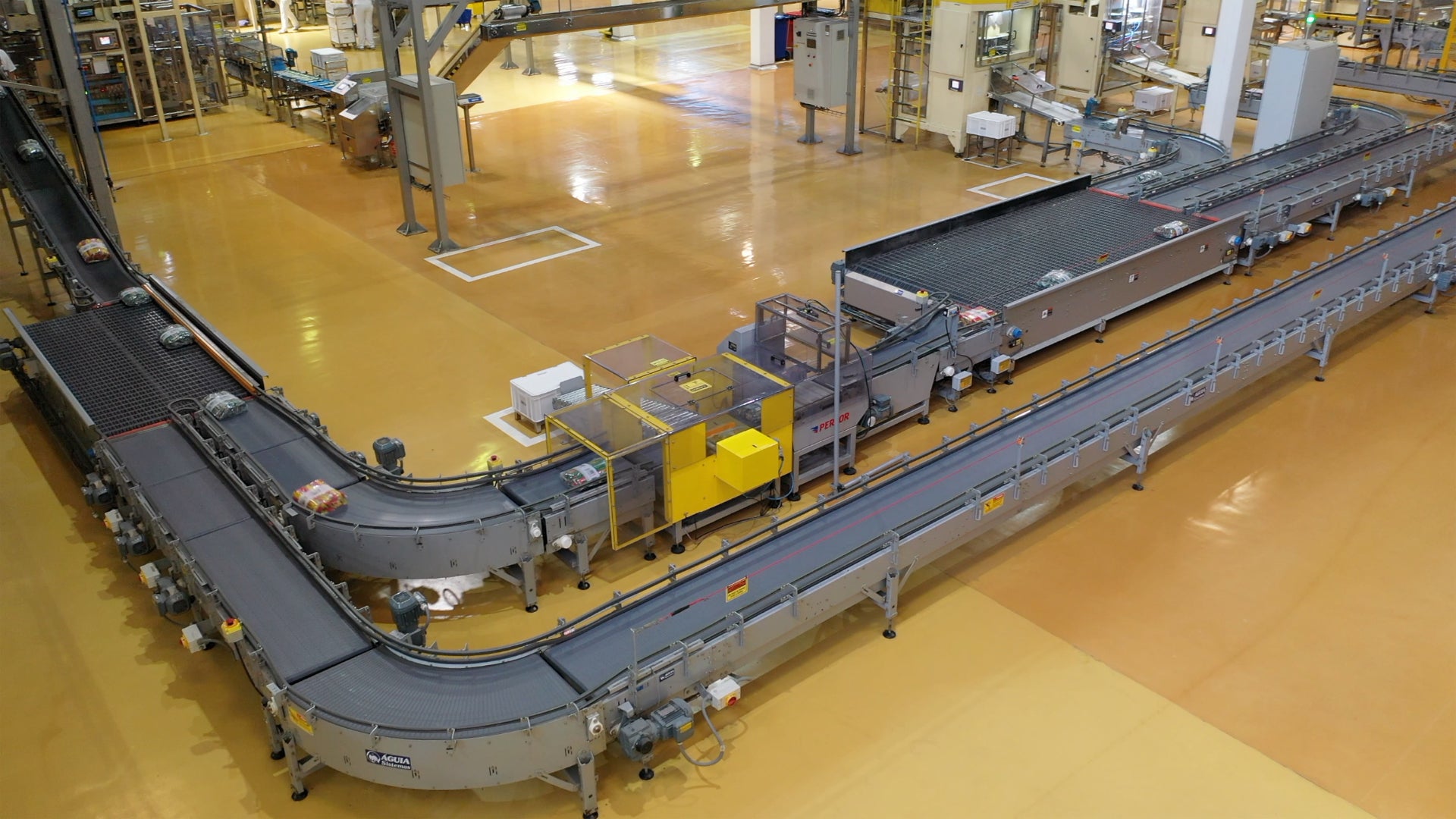 Overhead shot of M. Dias Branco installation with two equipment lines operating side by side around a curve