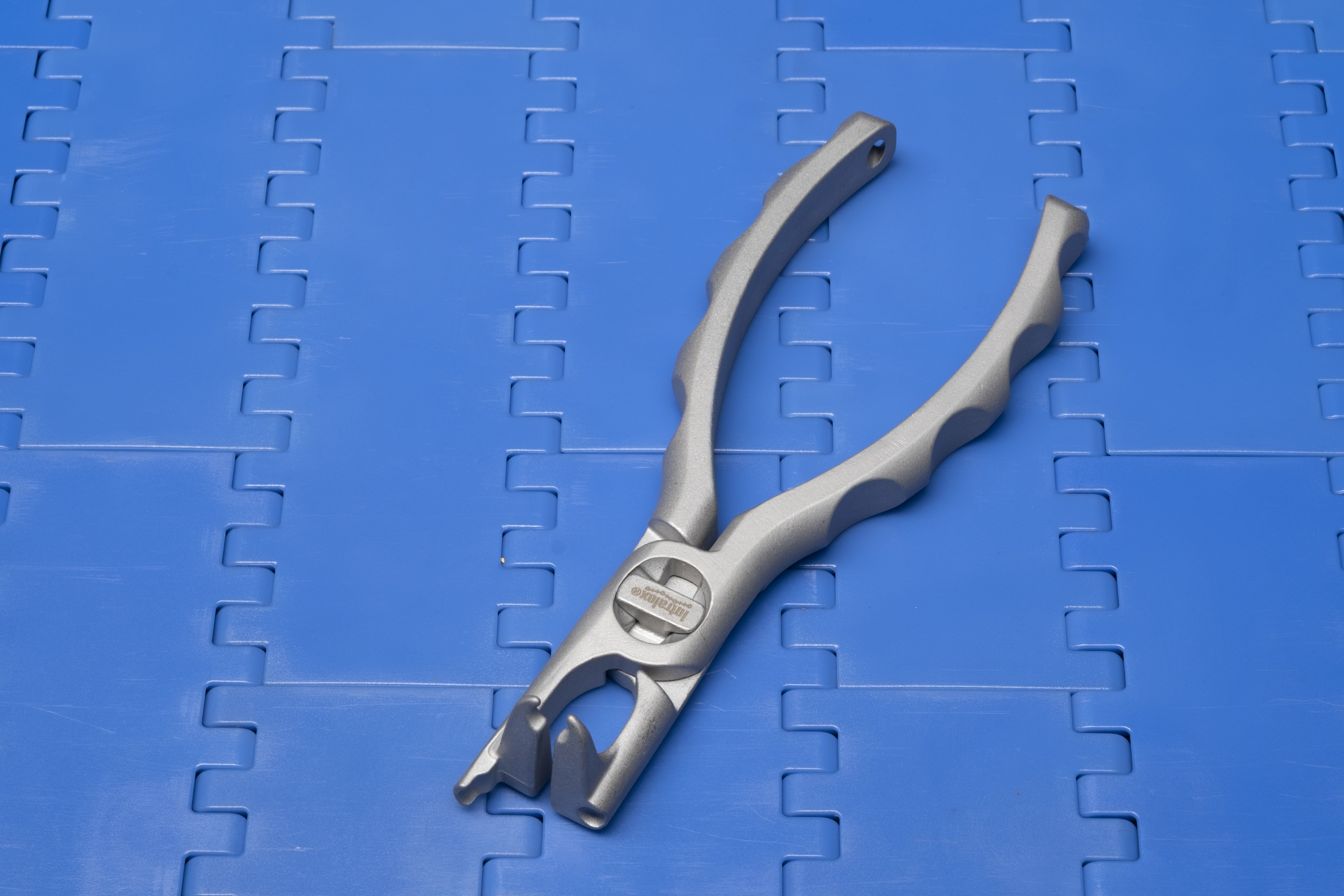 Intralox Scharnierstabwerkzeug auf blauem modularem Förderband