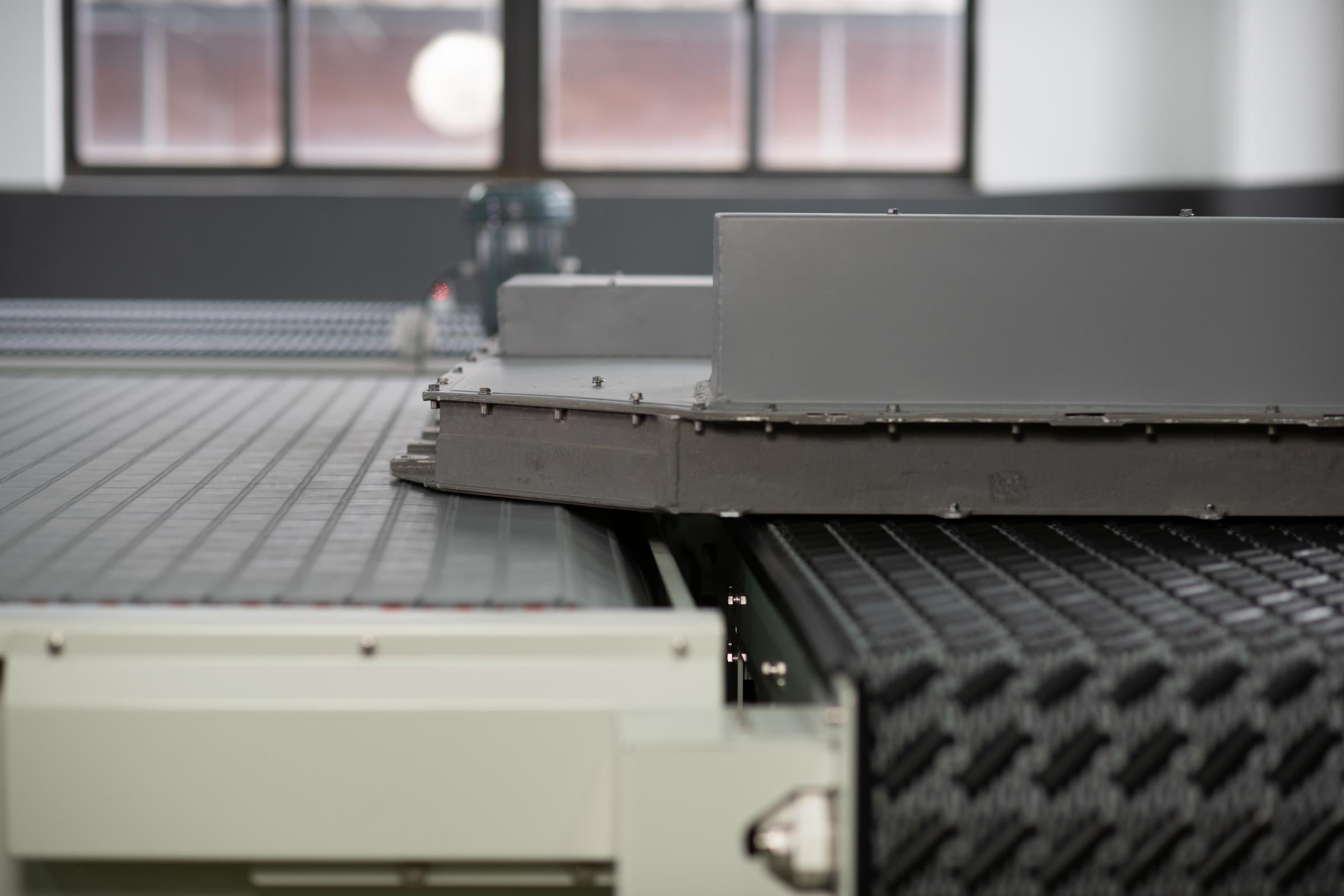 DARB S4500コンベアとS1400フラットトップベルト間で電気自動車バッテリーを直角乗継ぎ