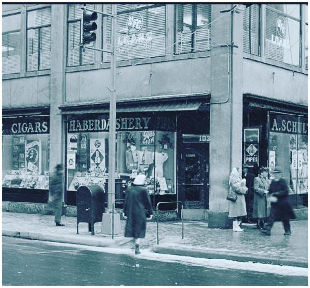 A woman holds the handrail of a ramp she is walking up from the street to the sidewalk.