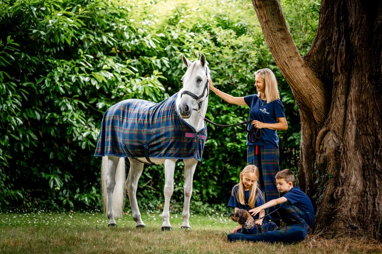 Une famille à côté d'un cheval, tous vêtus d'un pyjama de fête assorti.