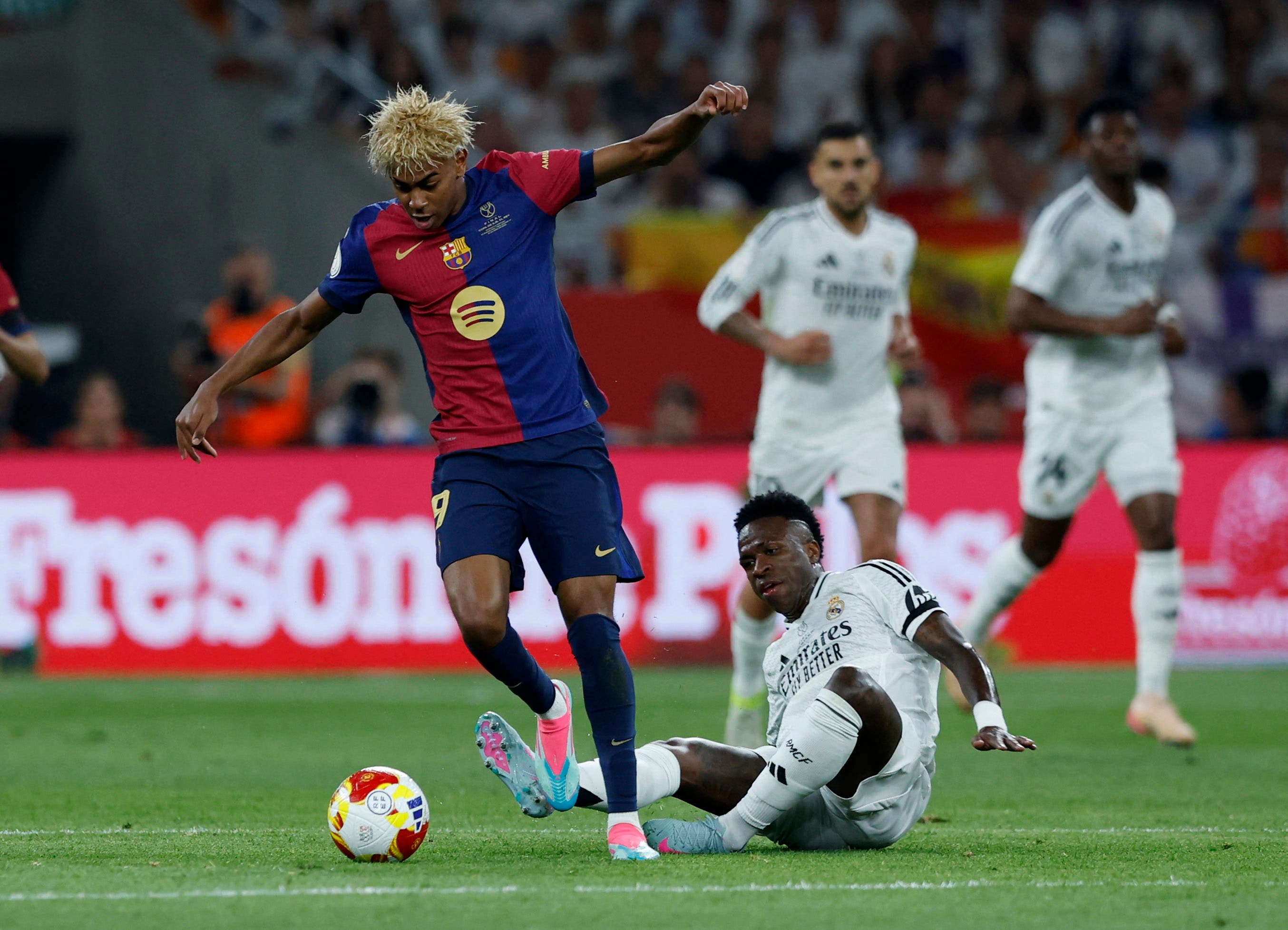 FC Barcelona's Lamine Yamal in action with Real Madrid's Vinicius Junior