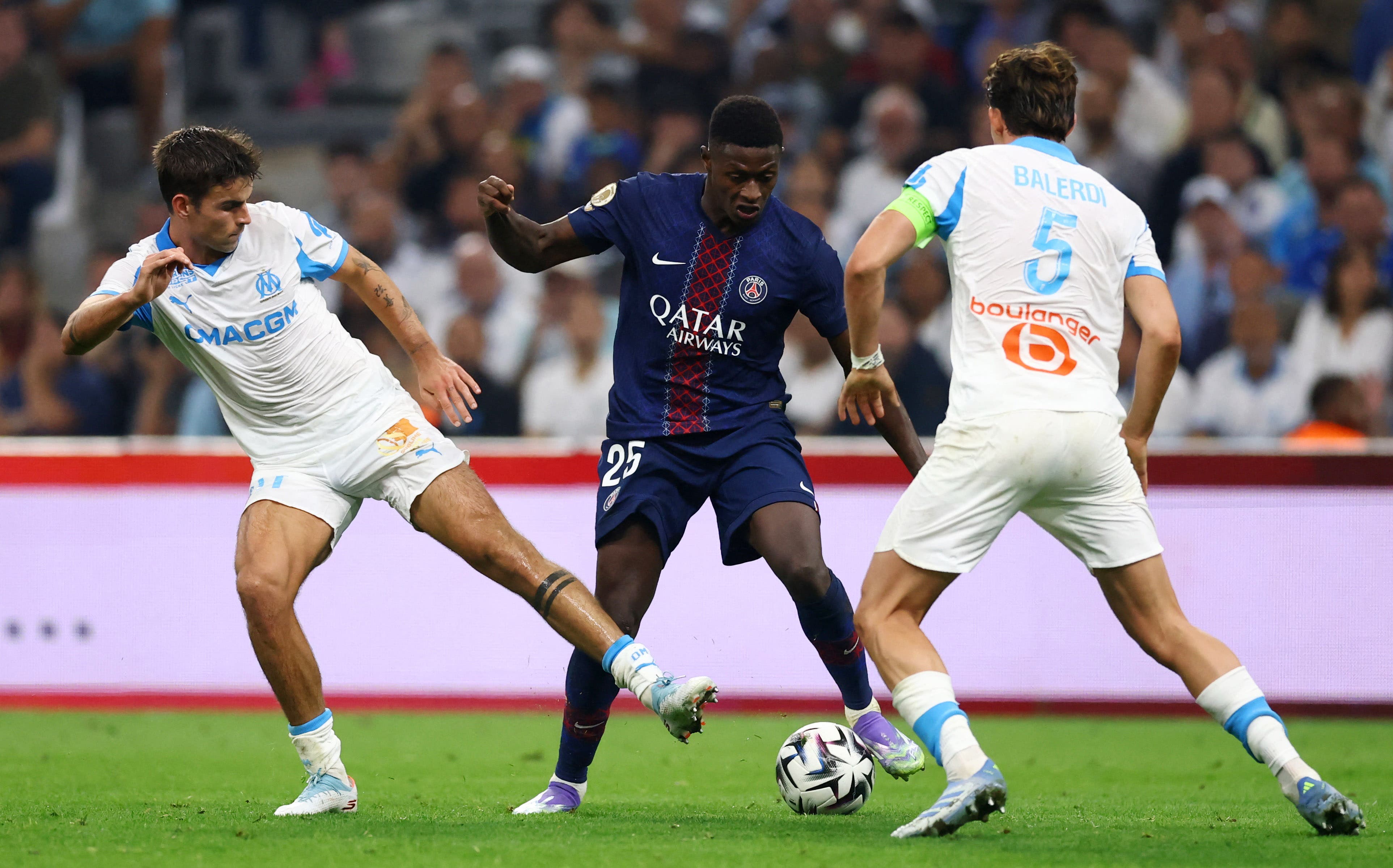 Soccer Football - Ligue 1 - Olympique de Marseille v Paris St Germain - Orange Velodrome, Marseille, France - September 22, 2025 Paris St Germain's Nuno Mendes in action with Olympique de Marseille's Leonardo Balerdi and Matt O'Riley REUTERS/Manon Cruz