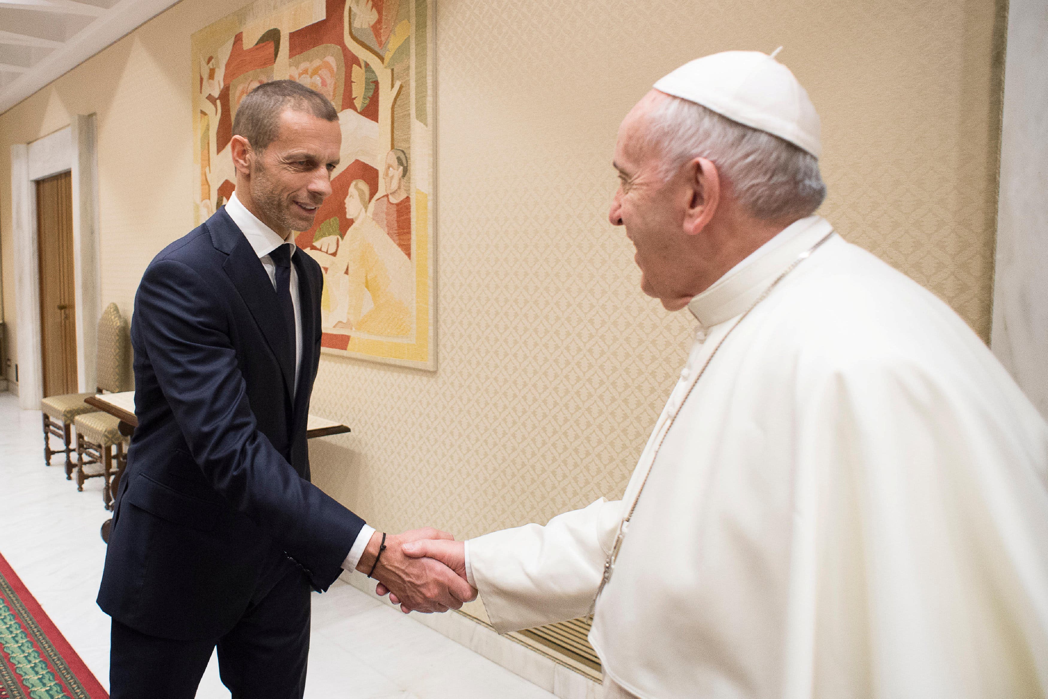 Pope Francis shakes hands with UEFA President Aleksander Ceferin at the Vatican 