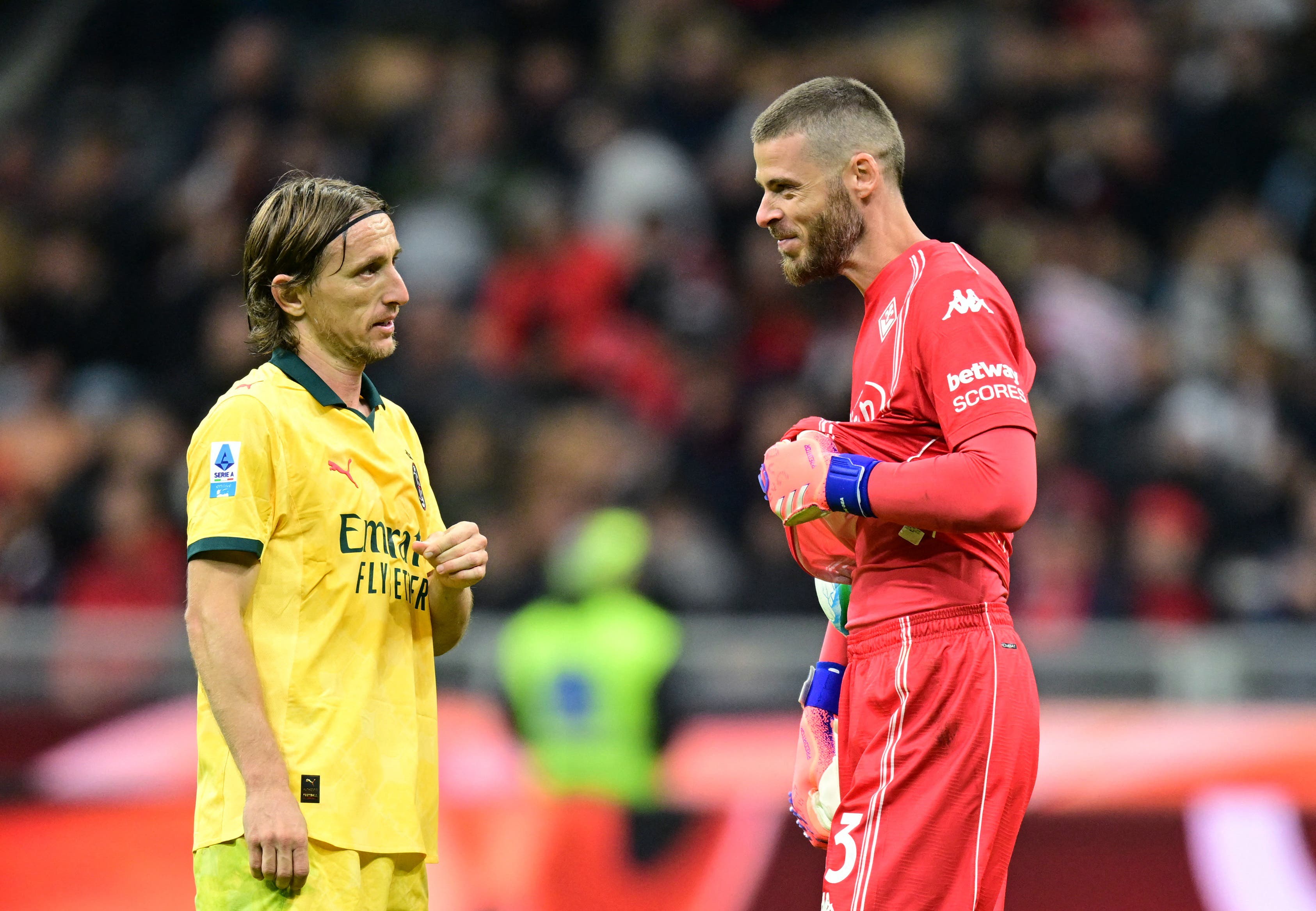 Soccer Football - Serie A - AC Milan v Fiorentina - San Siro, Milan, Italy - October 19, 2025 AC Milan's Luka Modric talks to Fiorentina's David de Gea after AC Milan are awarded a penalty following a VAR review REUTERS/Daniele Mascolo
