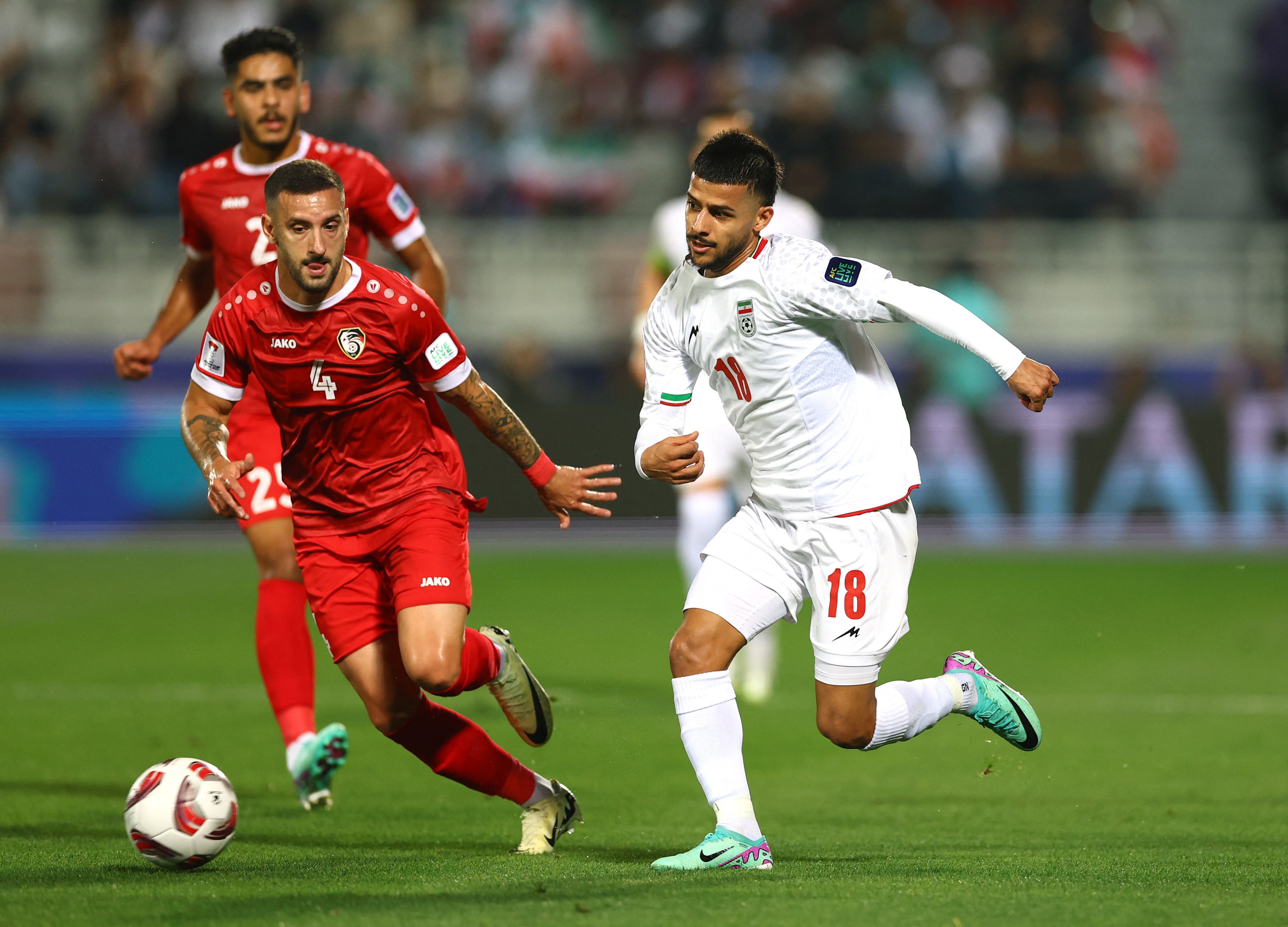 Soccer Football - AFC Asian Cup - Round of 16 - Iran v Syria - Abdullah bin Khalifa Stadium, Doha, Qatar - January 31, 2024 Iran's Mehdi Ghayedi in action with Syria's Ezequiel Ham REUTERS/Molly Darlington