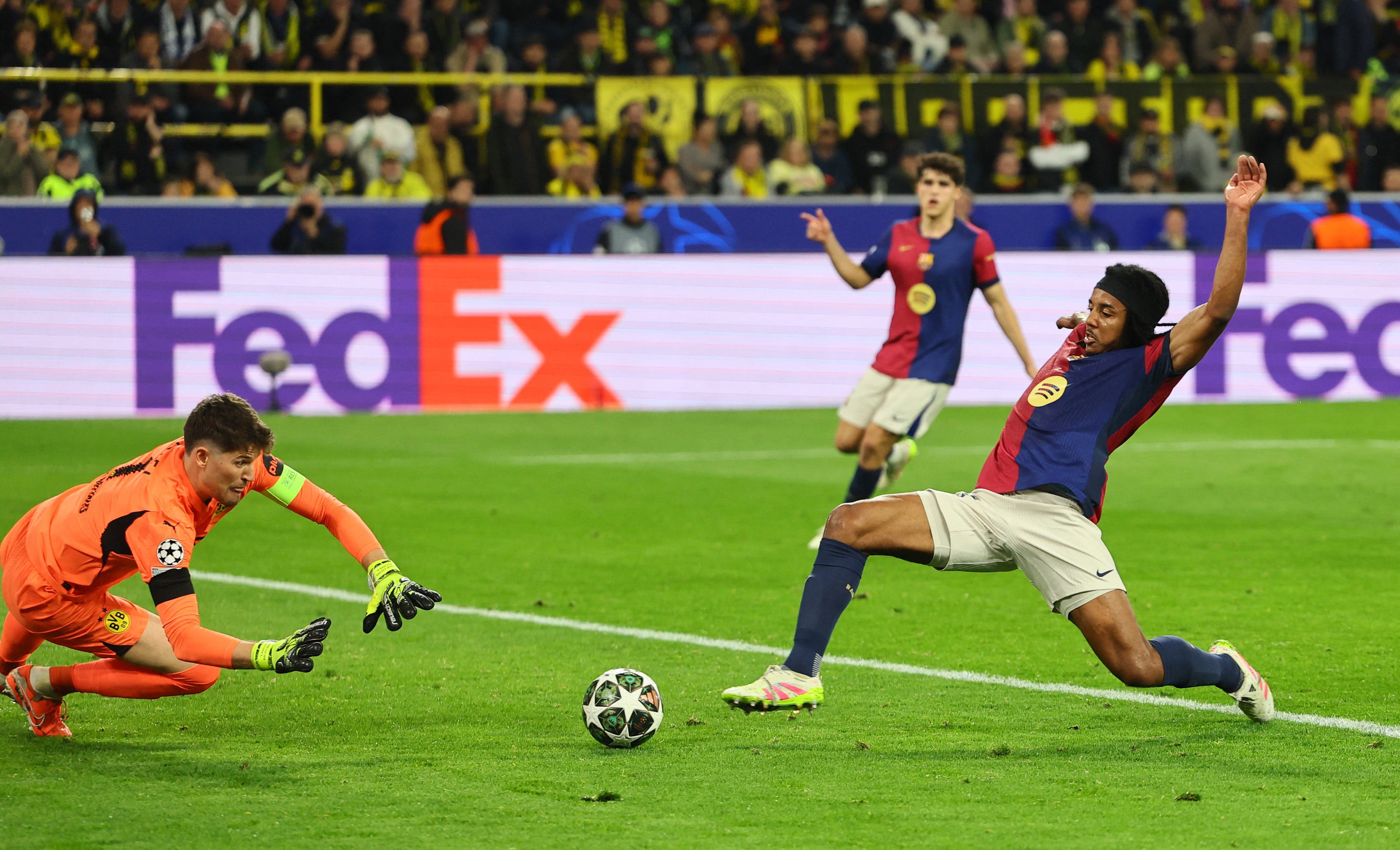 Borussia Dortmund's Gregor Kobel saves from FC Barcelona's Jules Kounde 