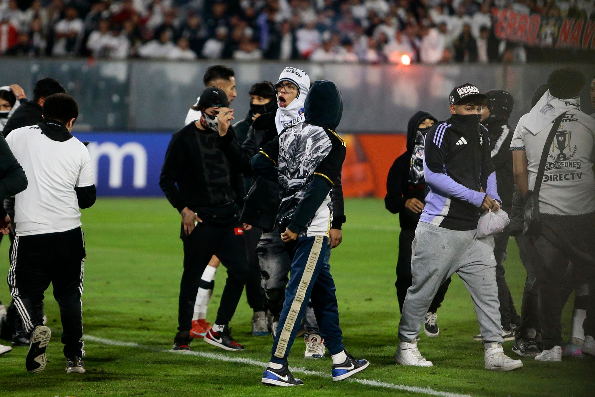 AME8108. SANTIAGO (CHILE), 10/04/2025.- Aficionados de Colo Colo invaden el campo de juego después de la muerte de dos hinchas asfixiados por una avalancha tras una carga policial este jueves, en un partido de la fase de grupos de la Copa Libertadores entre Colo Colo y Fortaleza en el estadio Monumental David Arellano, en Santiago (Chile). EFE/ Osvaldo Villarroel