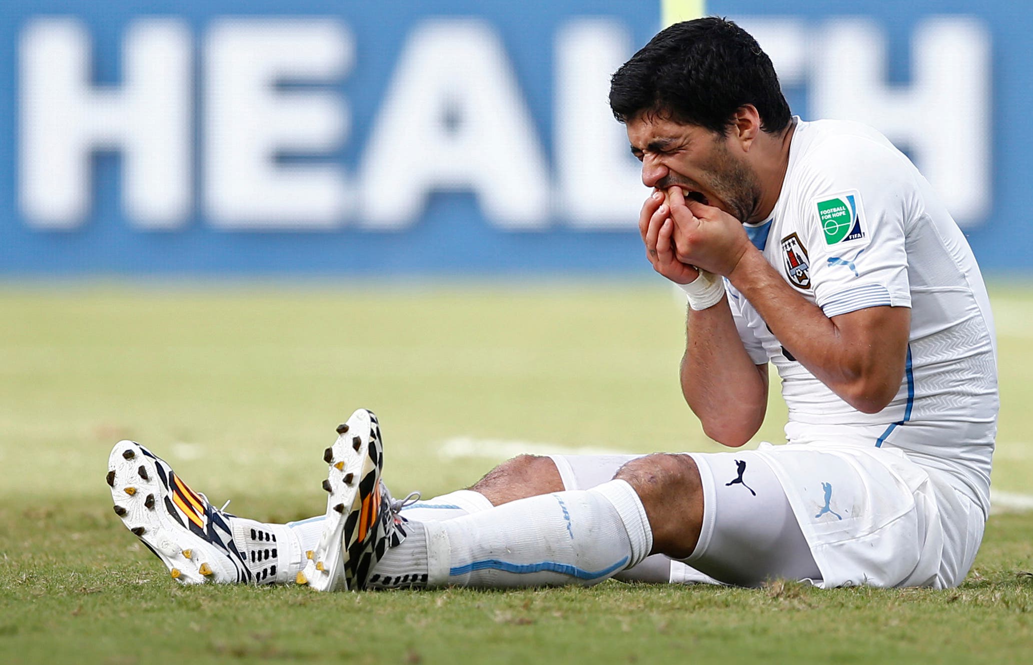 Football - Italy v Uruguay - FIFA World Cup Brazil 2014 - Group D - Estadio das Dunas, Natal, Brazil - 24/6/14 Uruguay's Luis Suarez holds his teeth after appearing to bite Italy's Giorgio Chiellini (not pictured) Mandatory Credit: Action Images / Andrew Boyers Livepic EDITORIAL USE ONLY.