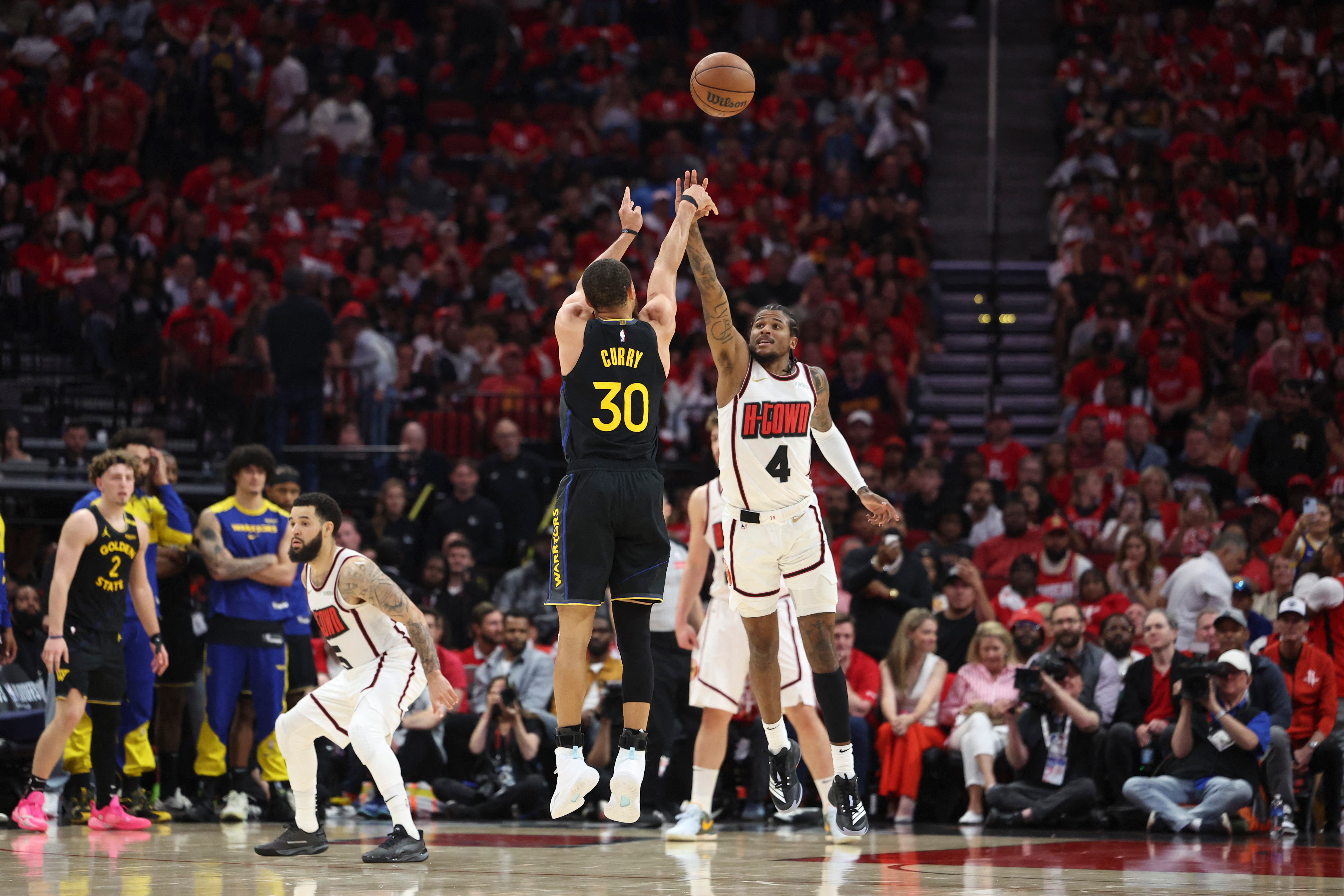 Golden State Warriors' Stephen Curry shooting over Houston Rockets' Jalen Green.