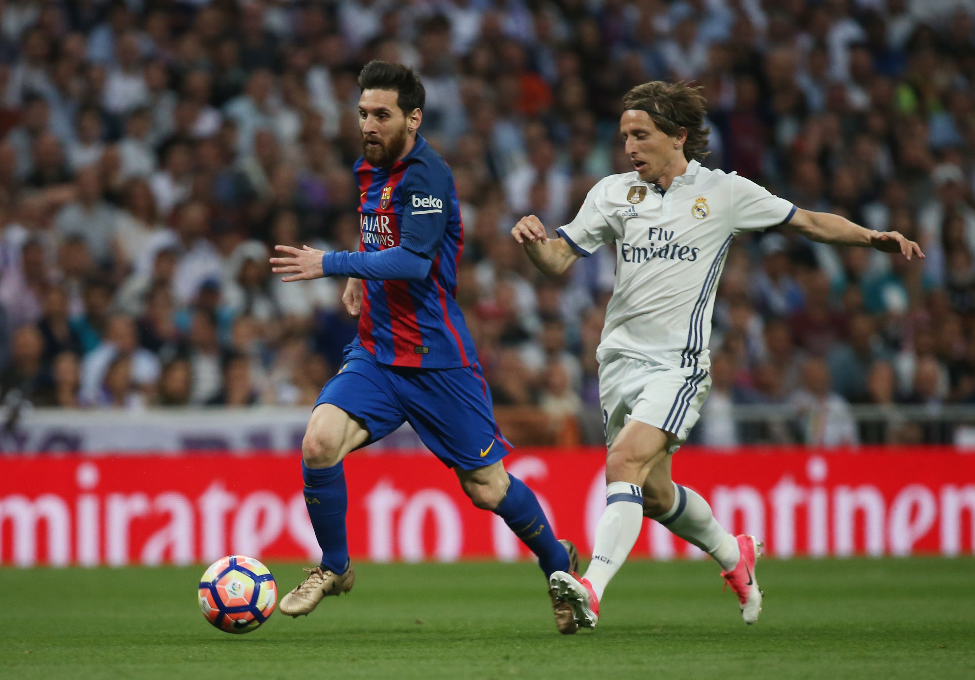 Real Madrid's Luka Modric in action with Barcelona's Lionel Messi