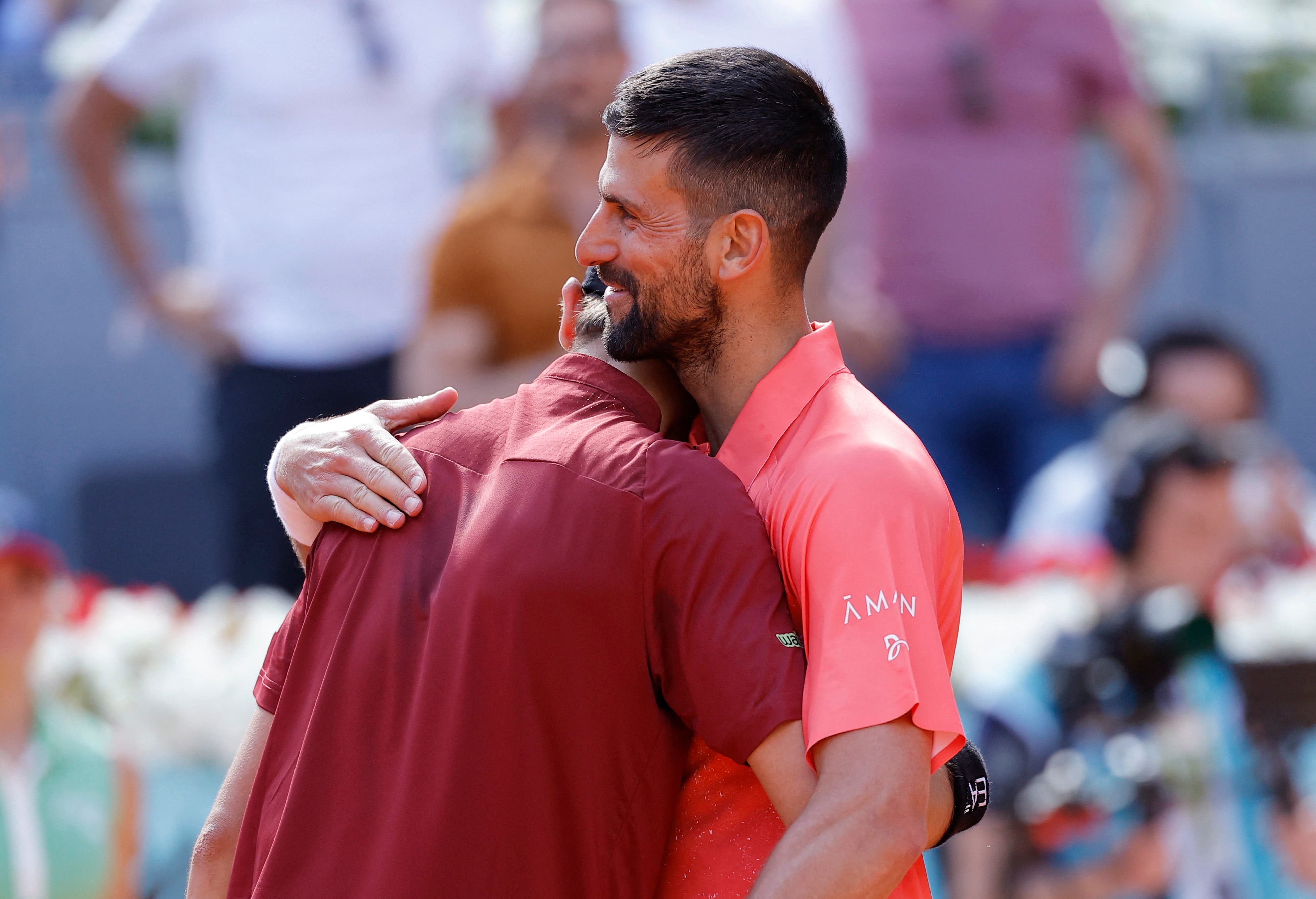 Tennis - Madrid Open - Park Manzanares, Madrid, Spain - April 26, 2025 Italy's Matteo Arnaldi hugs Serbia's Novak Djokovic after winning his round of 64 match REUTERS/Juan Medina
