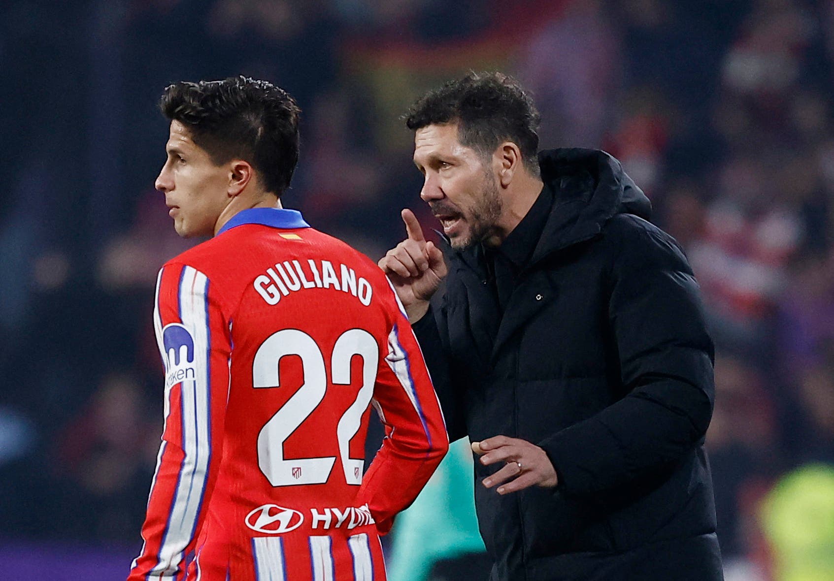 Atletico Madrid coach Diego Simeone talks to Atletico Madrid's Giuliano Simeone during the match