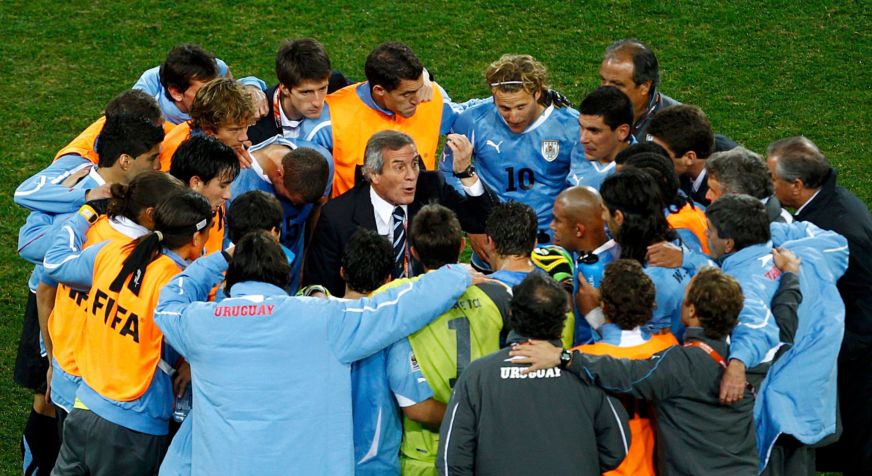 Uruguay's head coach Oscar Washington Tabarez talks to his team before the start of extra time during a 2010 World Cup quarter-final soccer match against Ghana at Soccer City stadium in Johannesburg July 2, 2010. REUTERS/Brian Snyder (SOUTH AFRICA - Tags: SPORT SOCCER WORLD CUP)