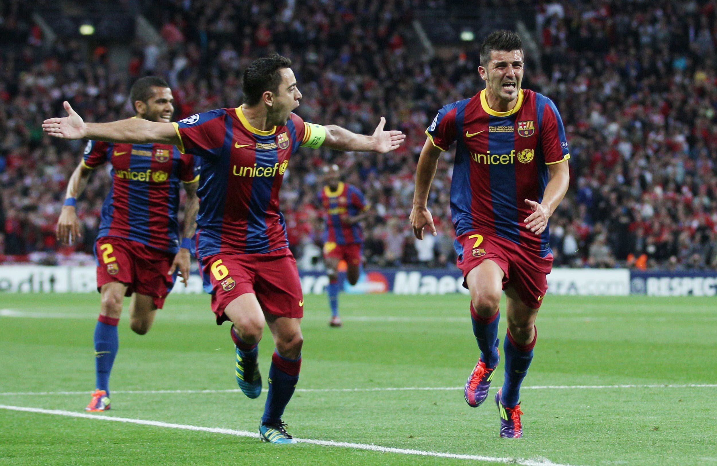 David Villa (R) celebrates scoring the third goal for Barcelona with Xavi