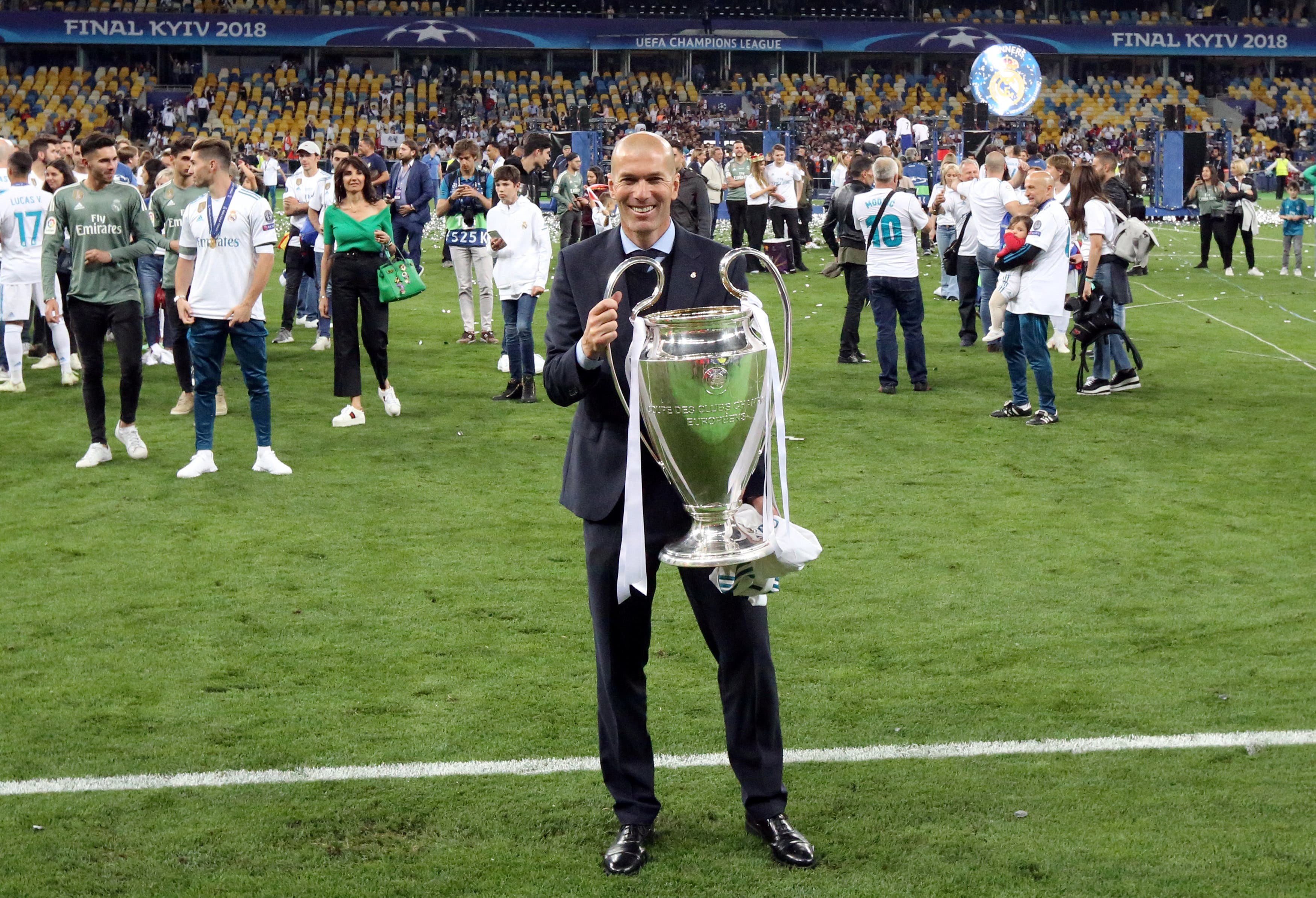 Real Madrid coach Zinedine Zidane poses with the trophy as he celebrates after winning the Champions League