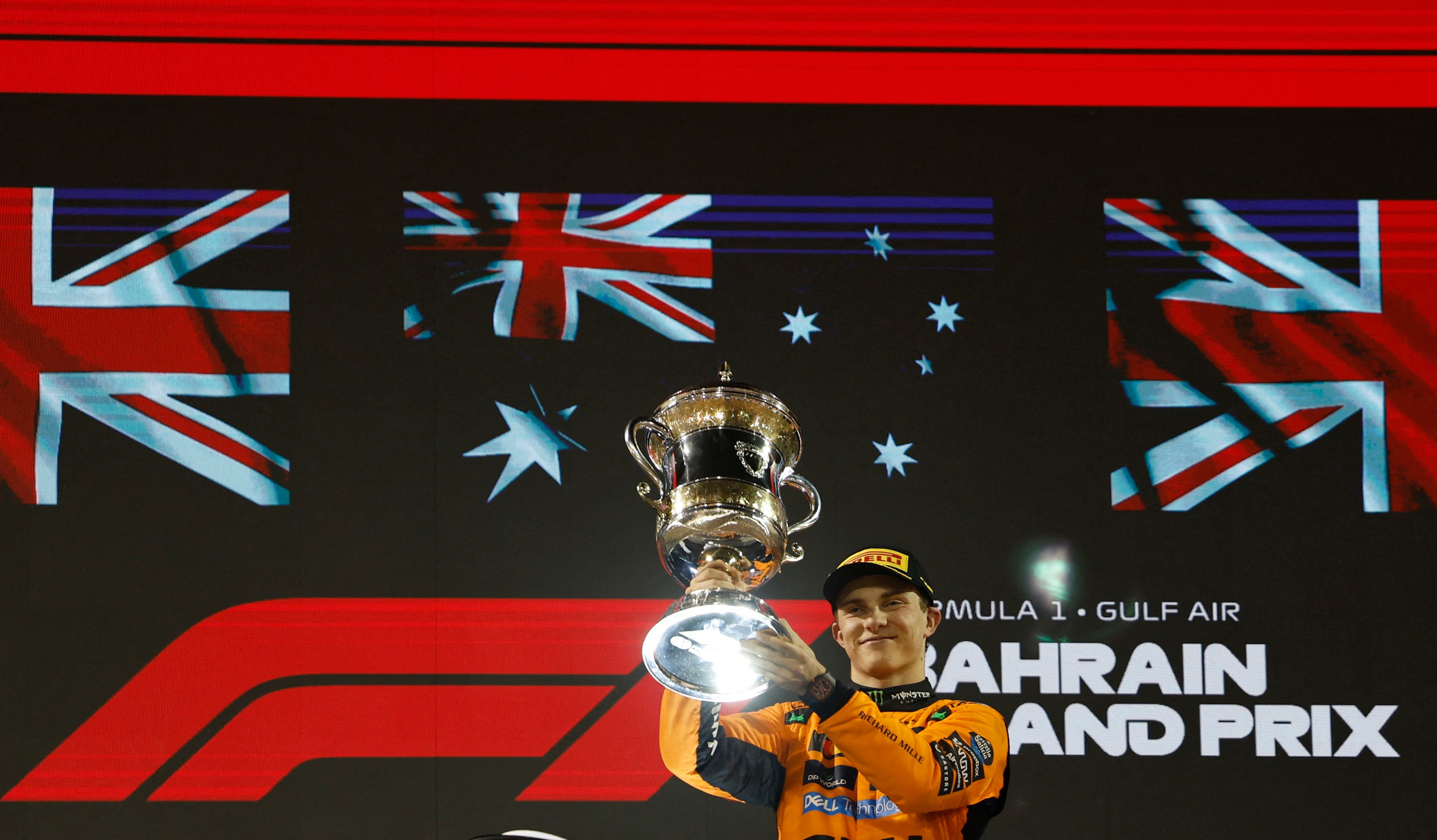 McLaren's Oscar Piastri celebrates with a trophy on the podium after winning the Bahrain Grand Prix
