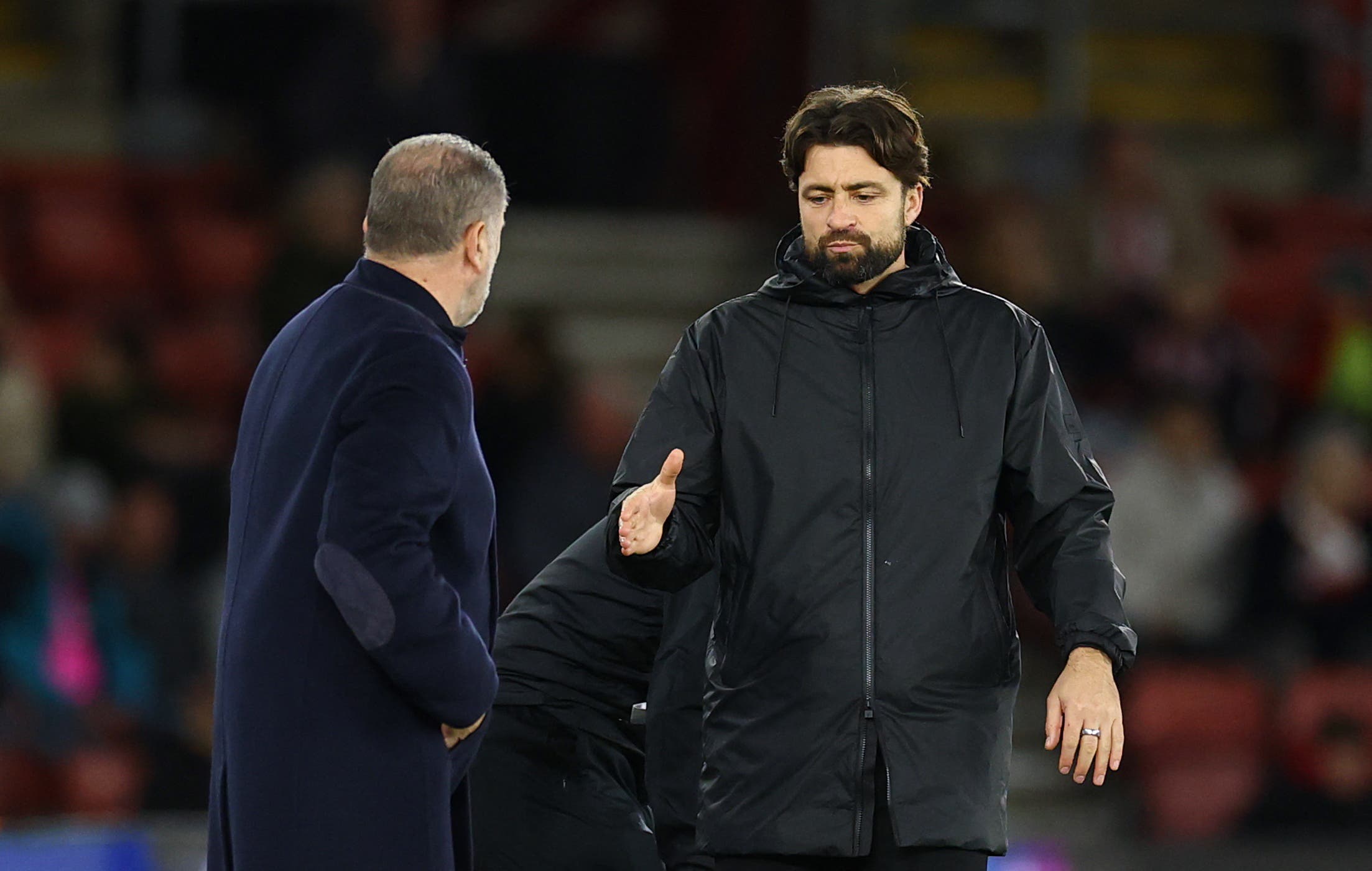 Russell Martin shakes hands with Tottenham Hotspur manager Ange Postecoglou.