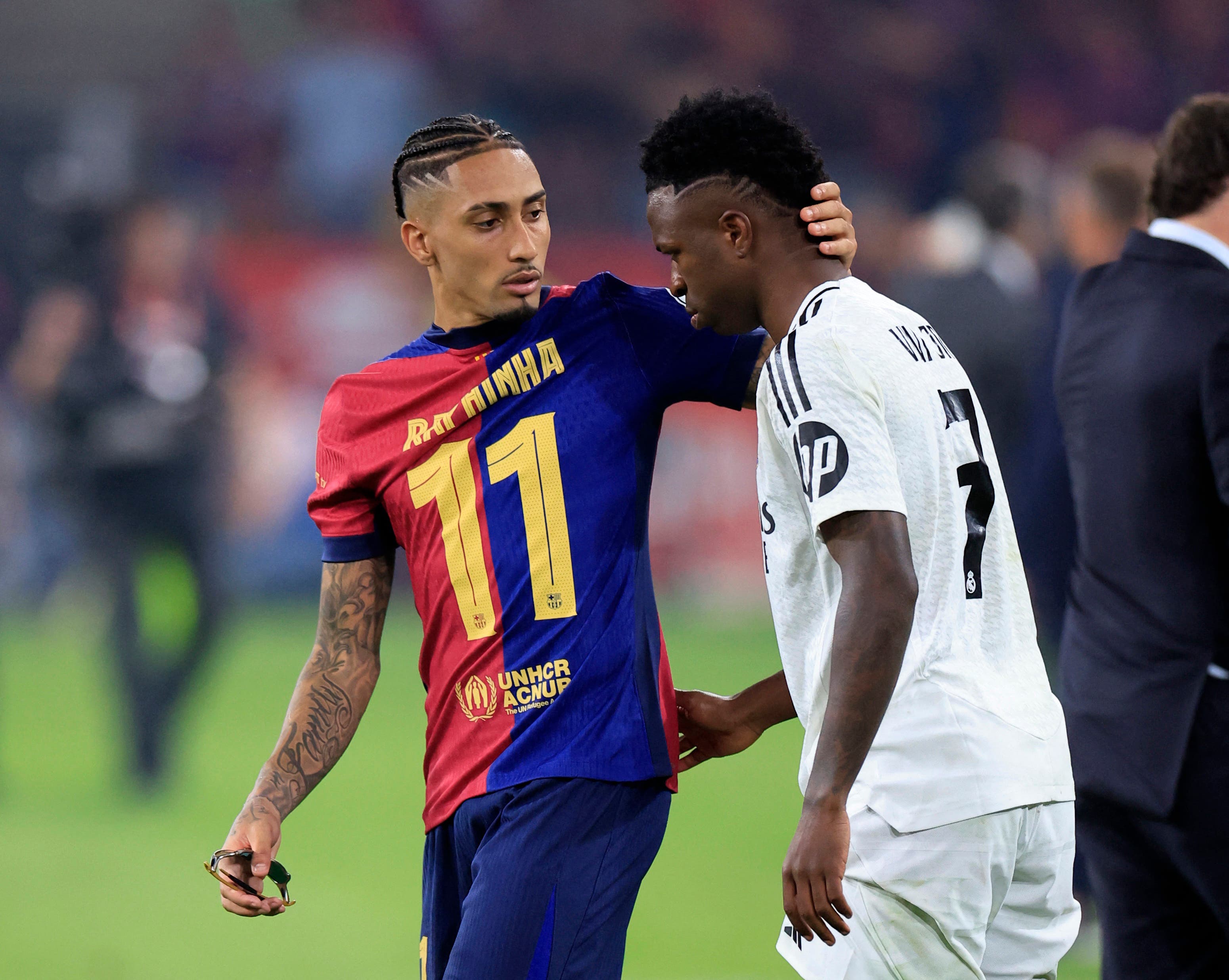 Soccer Football - Copa del Rey - Final - FC Barcelona v Real Madrid - Estadio de La Cartuja, Seville, Spain - April 27, 2025 FC Barcelona's Raphinha embraces Real Madrid's Vinicius Junior after the match REUTERS/Borja Suarez