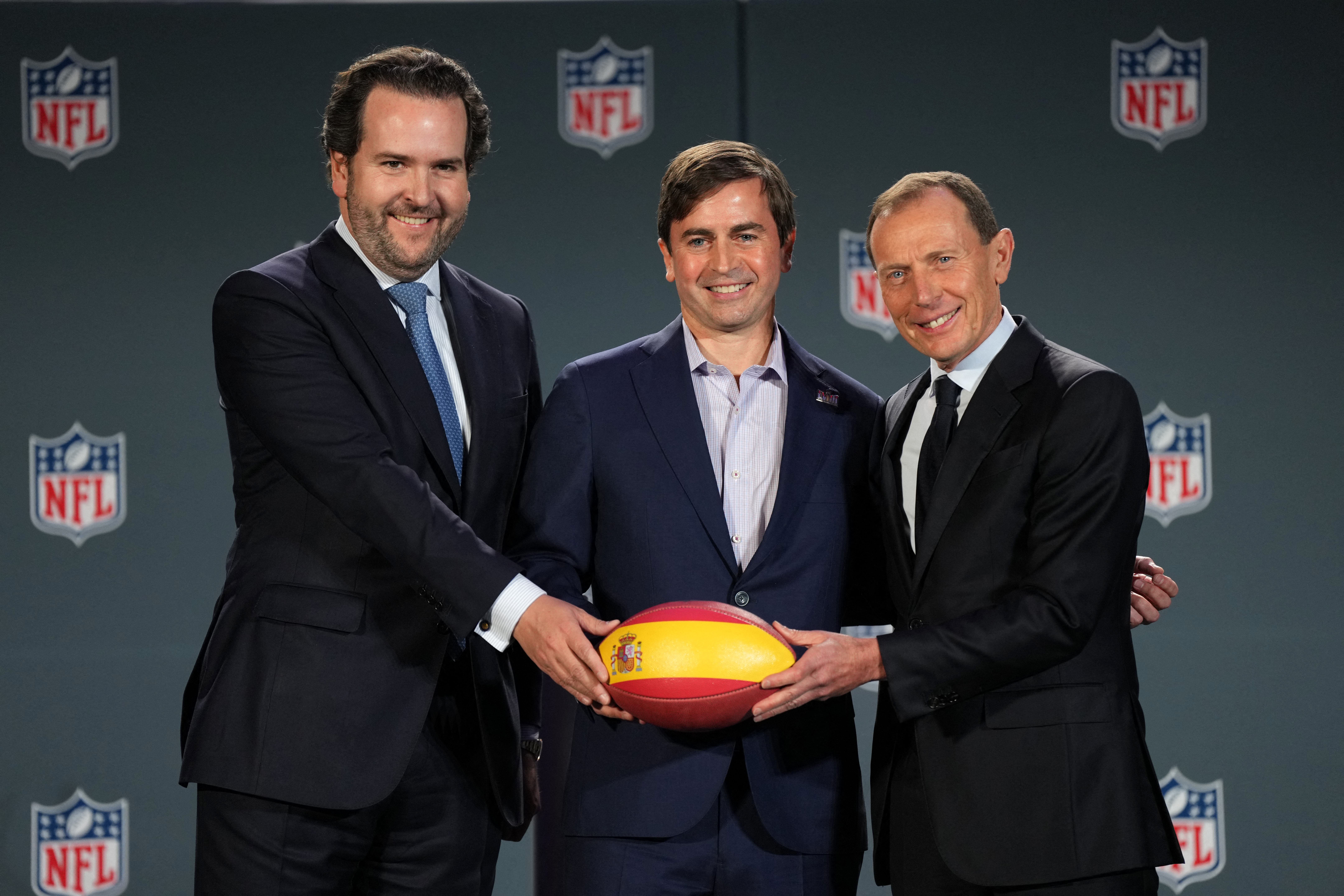 Feb 9, 2024; Las Vegas, NV, USA; Bernabeu Stadium chief executive officer Santiago Lopez Vilas (left), NFL International executive vice president Peter O'Reilly (center) and Real Madrid C.F. institutional relations director Emilio Butragueno hold a football during a press conference to announce Madrid as host of NFL regular season International Series game at Santiago Bernabeu Stadium in 2025. Mandatory Credit: Kirby Lee-USA TODAY Sports