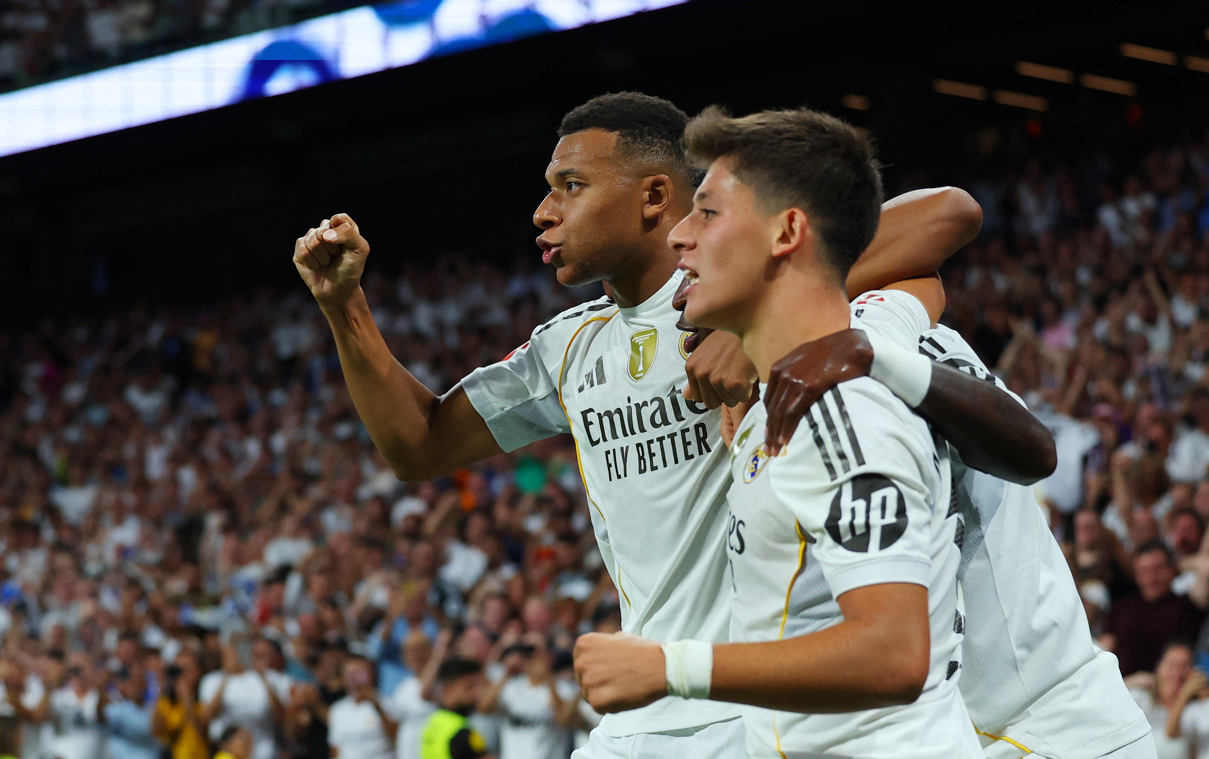 Arda Güler celebrates alongside Kylian Mbappé and Vinicius during a match with Real Madrid.