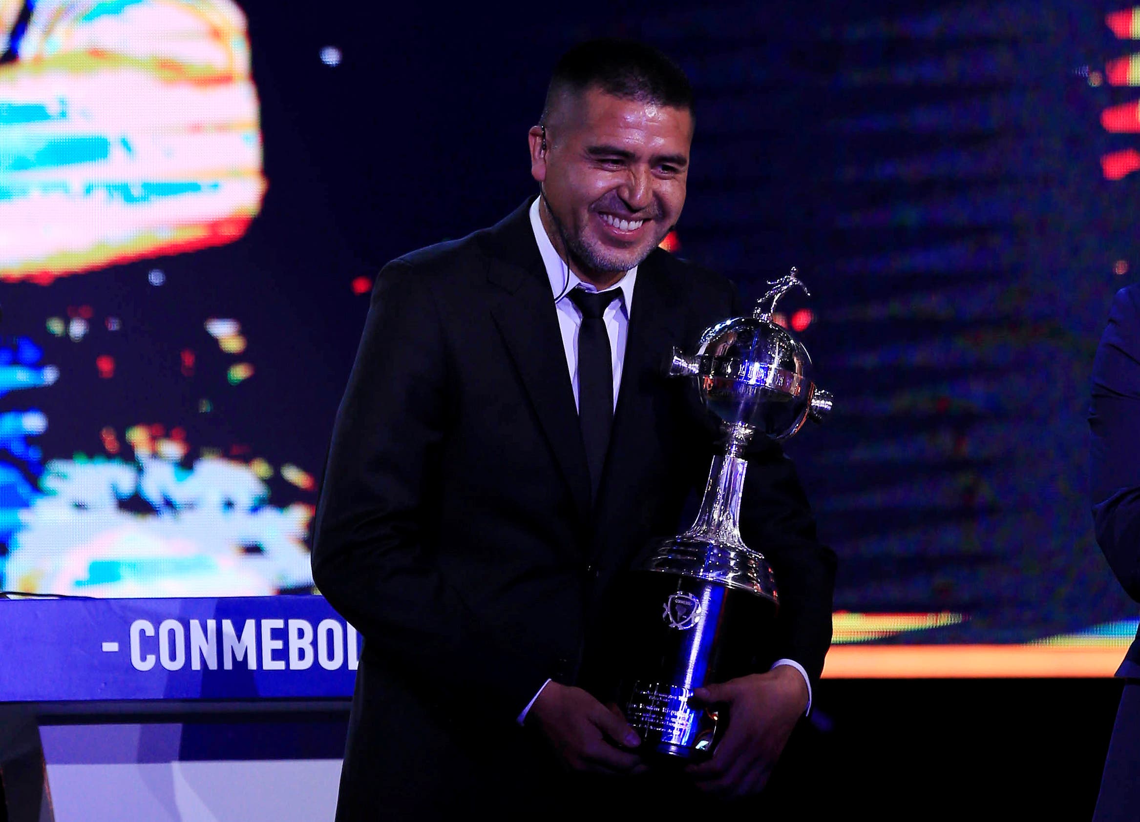 Soccer Football - Copa Libertadores 2020 Draw - CONMEBOL Headquarters - Luque, Paraguay - December 17, 2019 Boca Juniors legend Juan Roman Riquelme receives a replica of the Libertadores trophy during the draw REUTERS/Jorge Adorno

