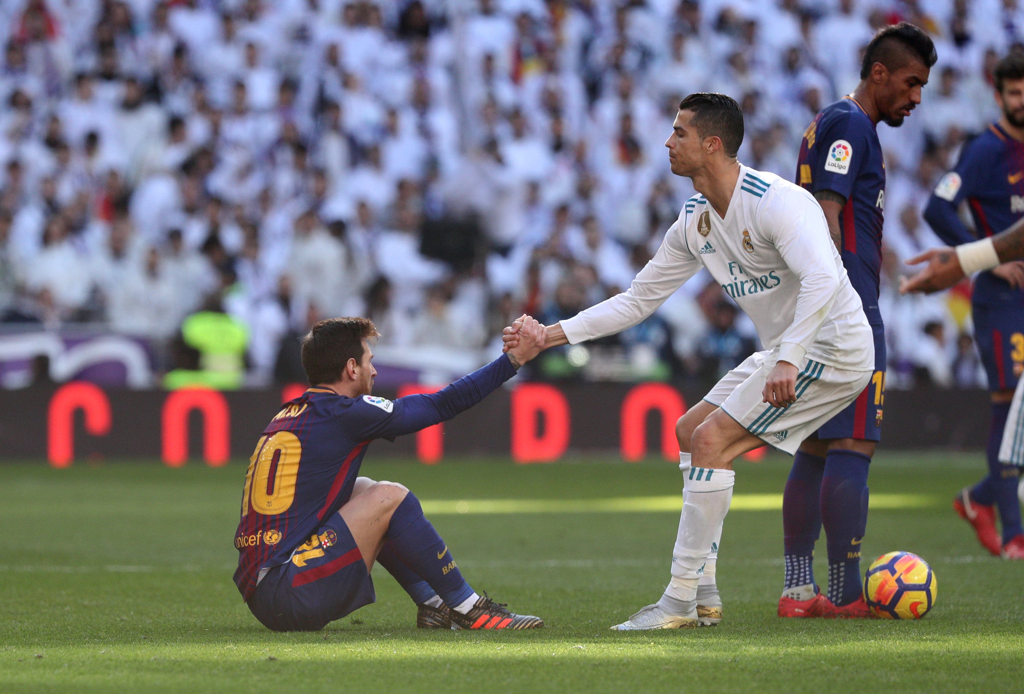 Real Madrid’s Cristiano Ronaldo helps Barcelona’s Lionel Messi get back to his feet 