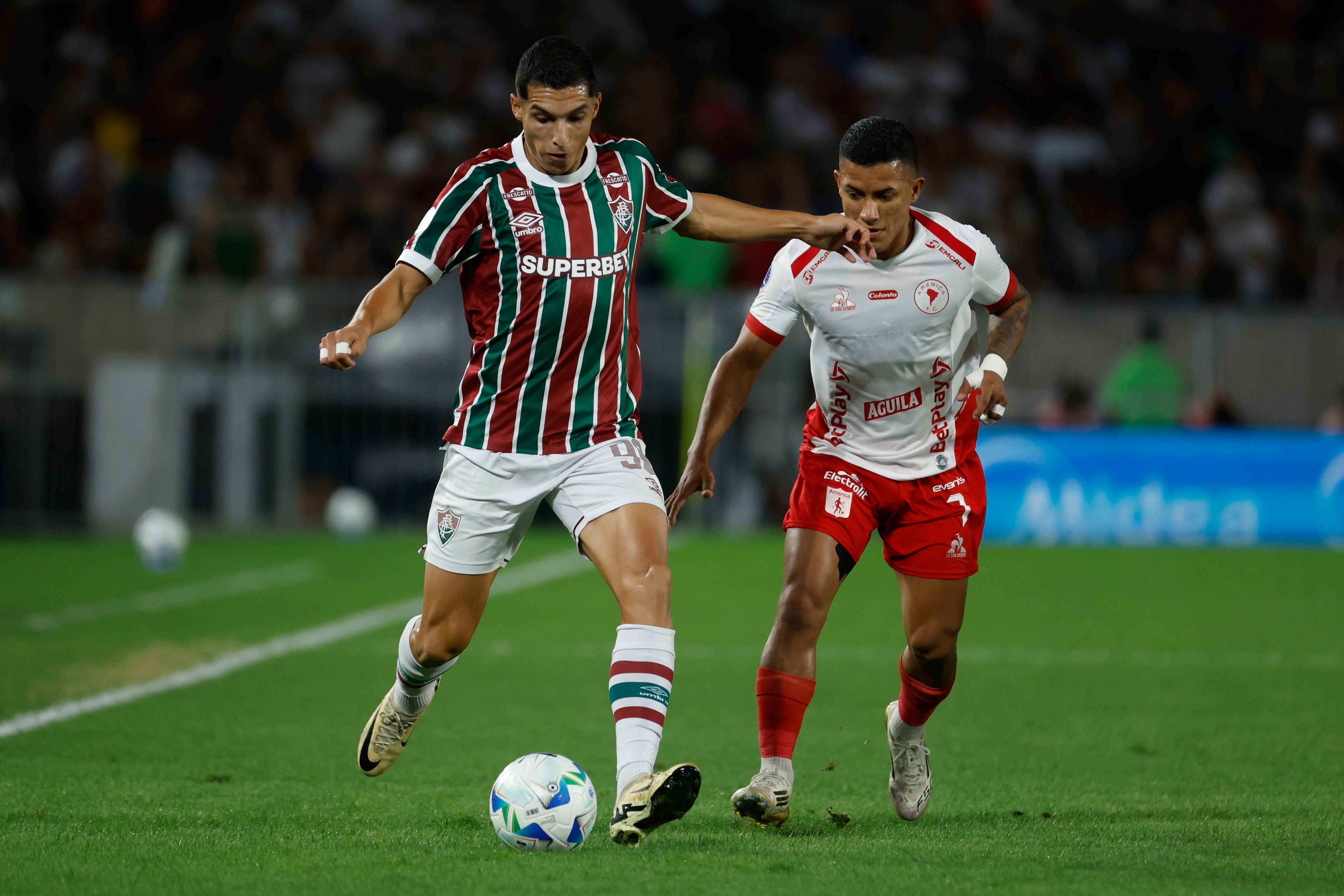 AME1875. RÍO DE JANEIRO (BRASIL), 19/08/2025.- Kevin Serna (i) de Fluminense disputa el balón con Cristian Barrios de América este martes, en un partido de los octavos de final de la Copa Sudamericana entre Fluminense y América en el estadio Maracaná en Río de Janeiro (Brasil). EFE/ Antonio Lacerda
