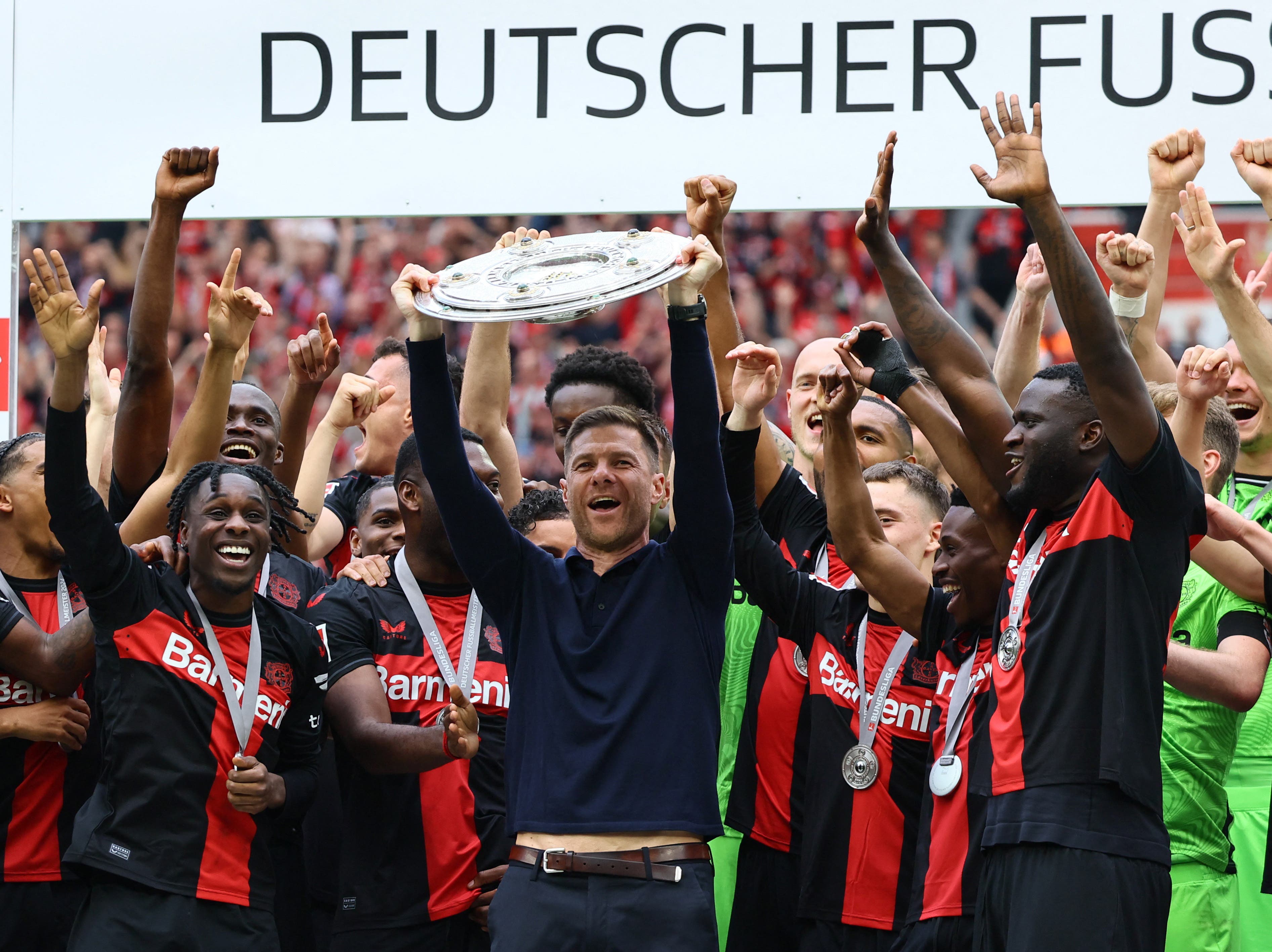 Bayer Leverkusen coach Xabi Alonso celebrates with the trophy 