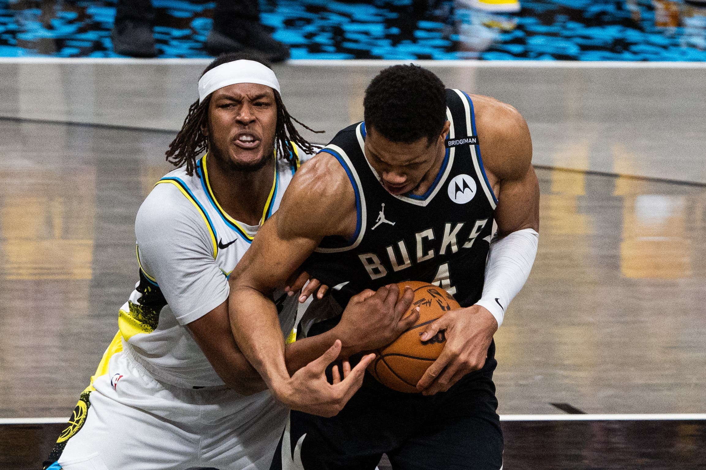 Milwaukee Bucks' Giannis Antetokounmpo fighting for the ball against Indiana Pacers' player.