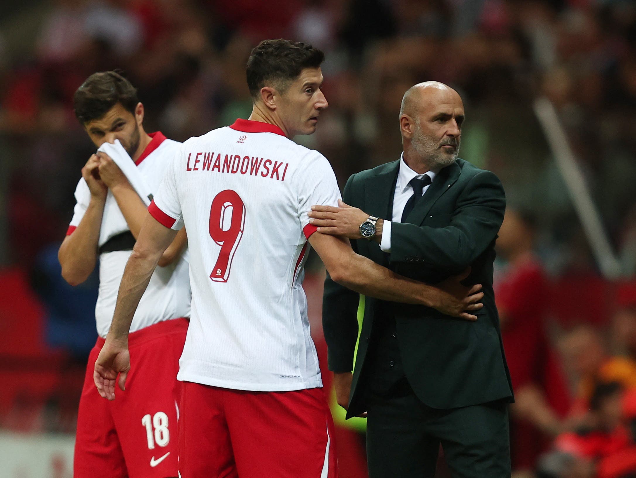 Poland's Robert Lewandowski with coach Michal Probierz before he comes on as a substitute to replace Piotr Zielinski 
